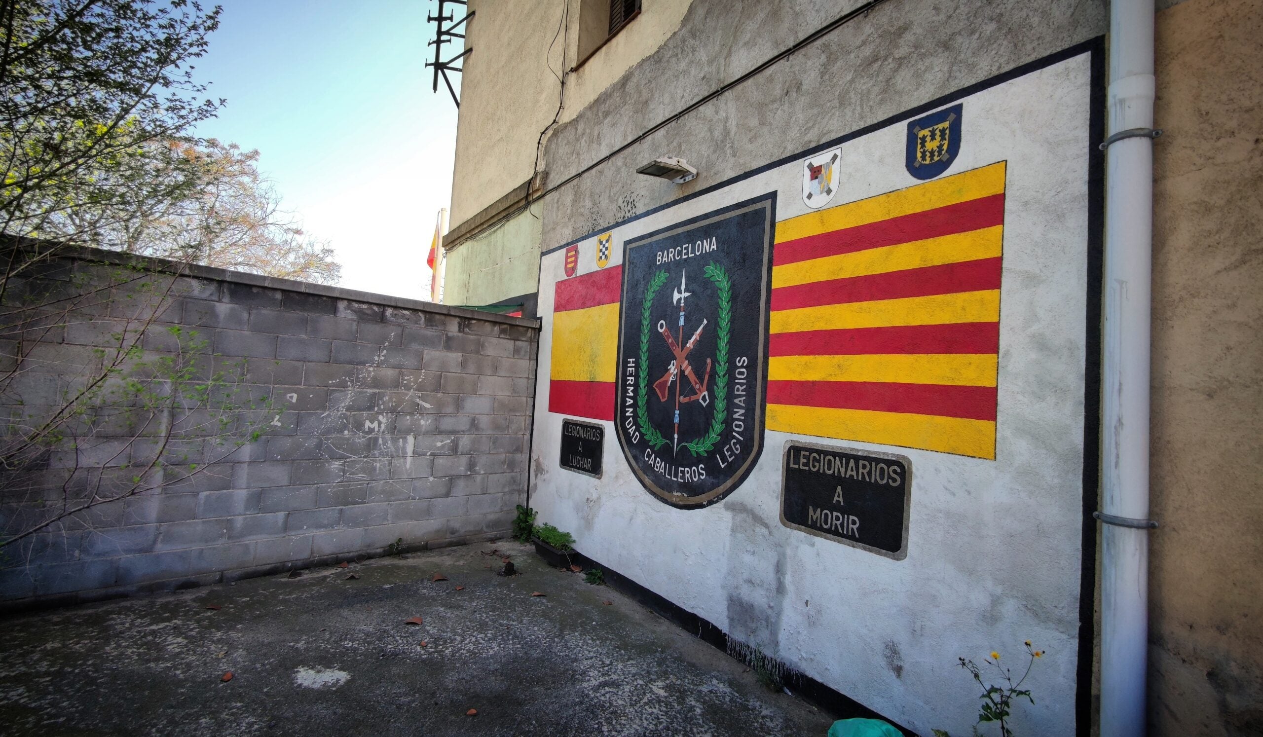 L'escut dels legionaris establerts a Sant Andreu, a la façana lateral del local, vista des del carrer / D.C.