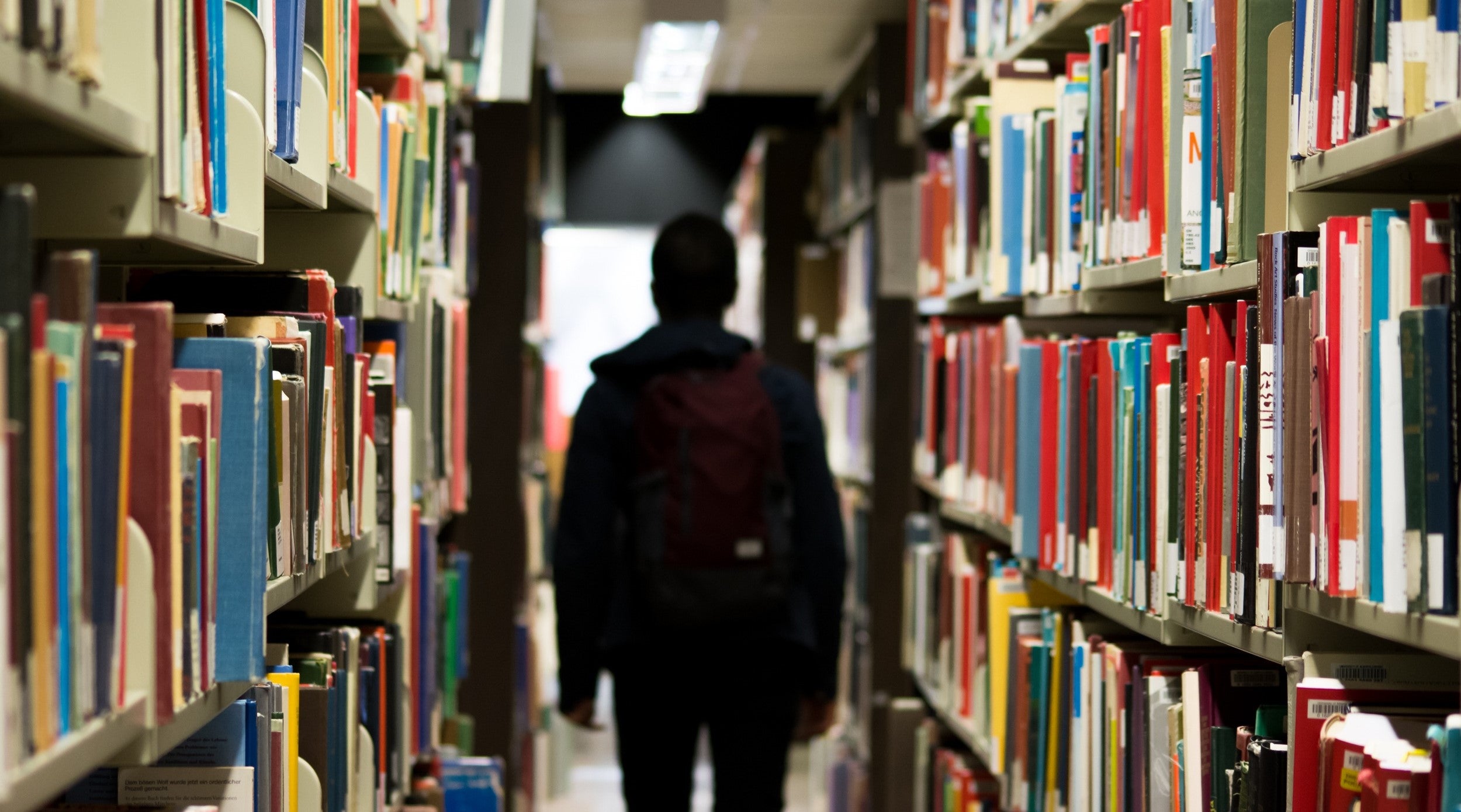 Imatge de recurs d'un home envoltat de llibres / Pixy