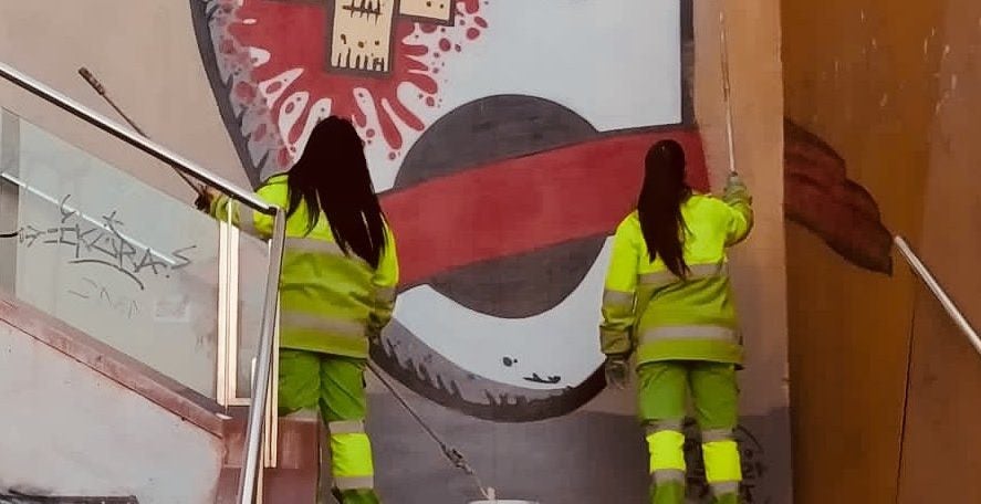 Dos operàries de neteja esborren el mural de Txinorri pròxim a la Kasa de la Muntanya / KM