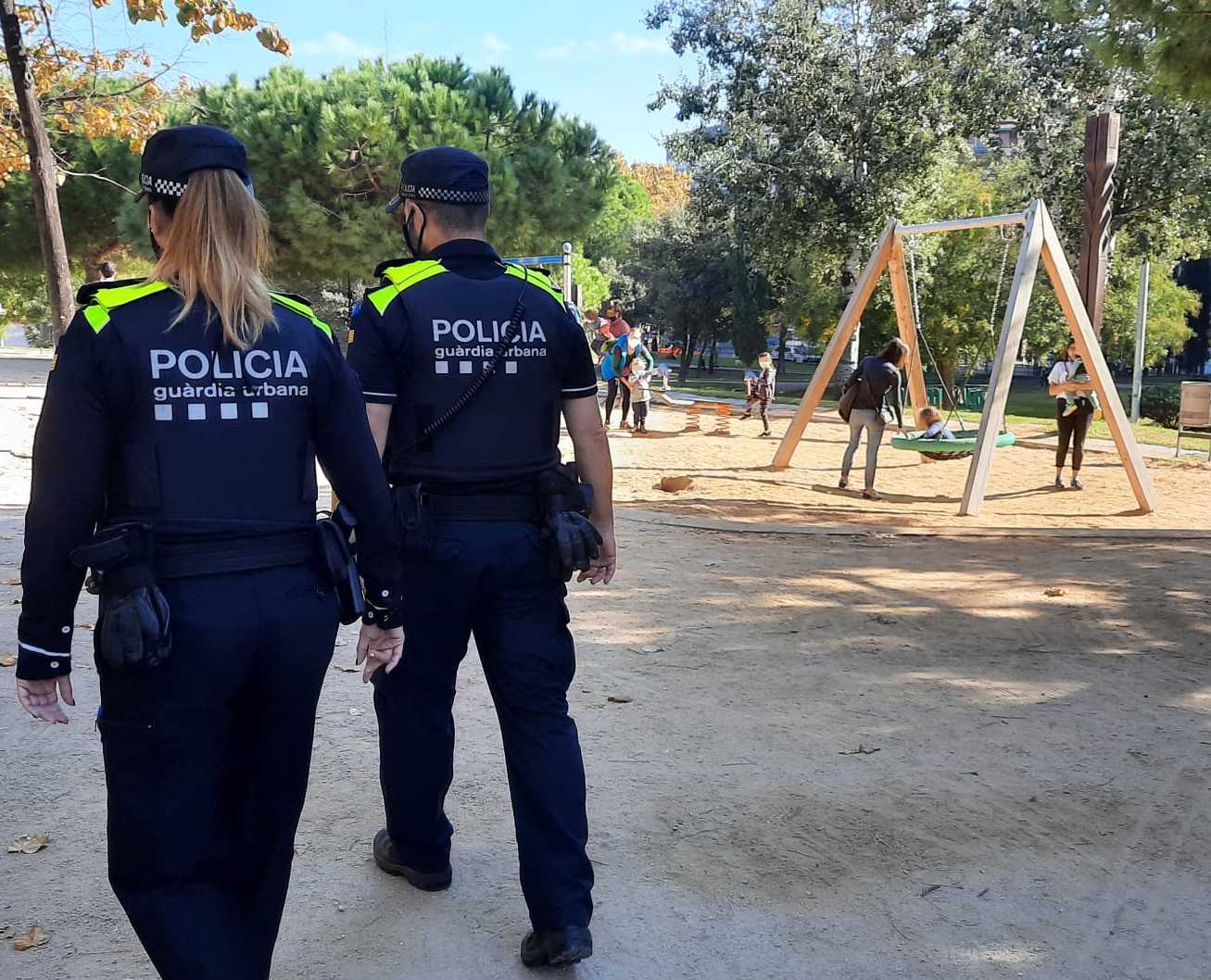 Dos agents de la Guàrdia Urbana patrullant en un parc infantil / GUB