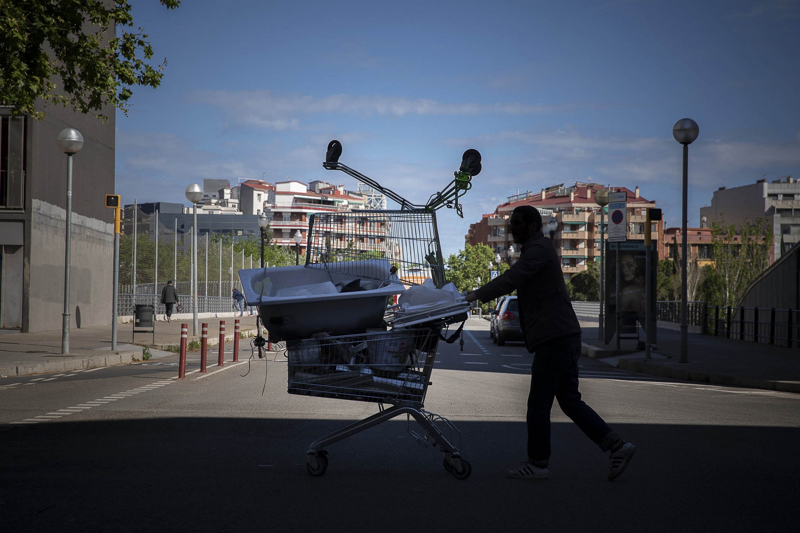 Un home empenyent un carro ple de ferralla, prop de l'Estació del Nord / Jordi Play