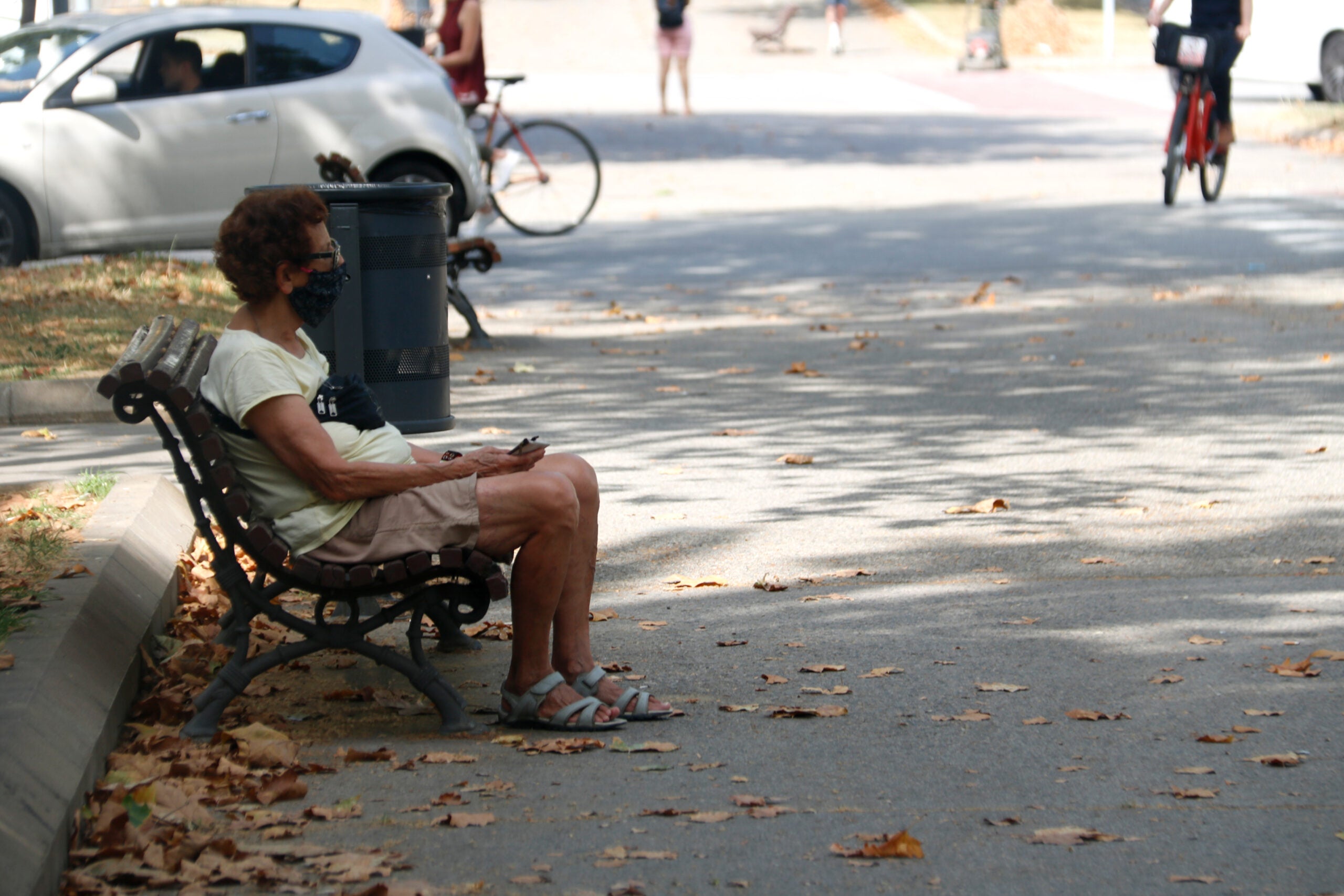 Una dona gran, amb mascareta asseguda en un banc, a Barcelona el 09/07/2020 (horitzontal)