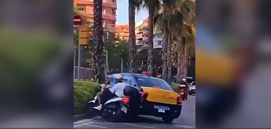 El taxi fent caure el motociclista i el menor / Twitter