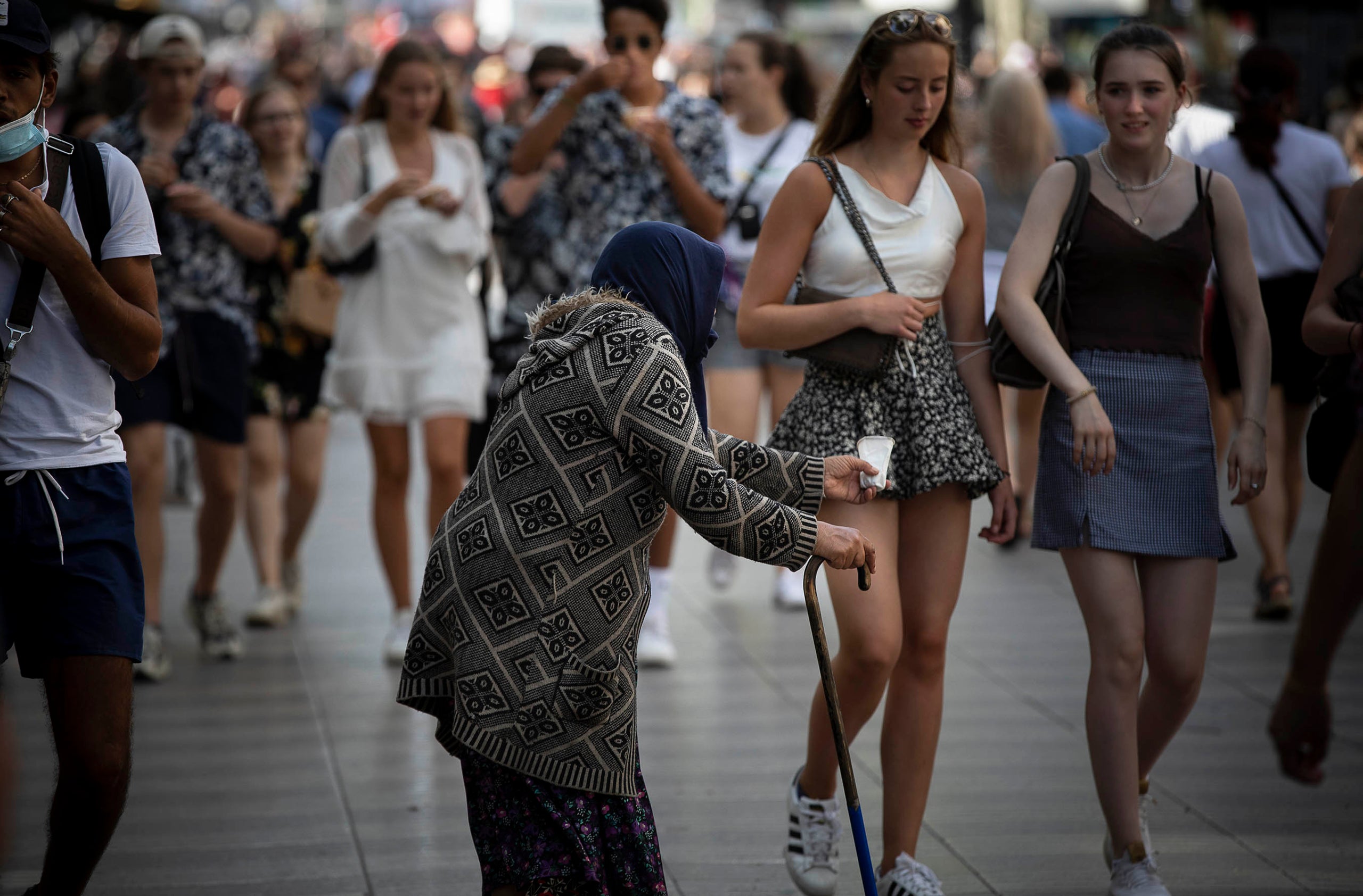 Una senyora demana almoina a Les Rambles en una imatge d'arxiu / Jordi Play