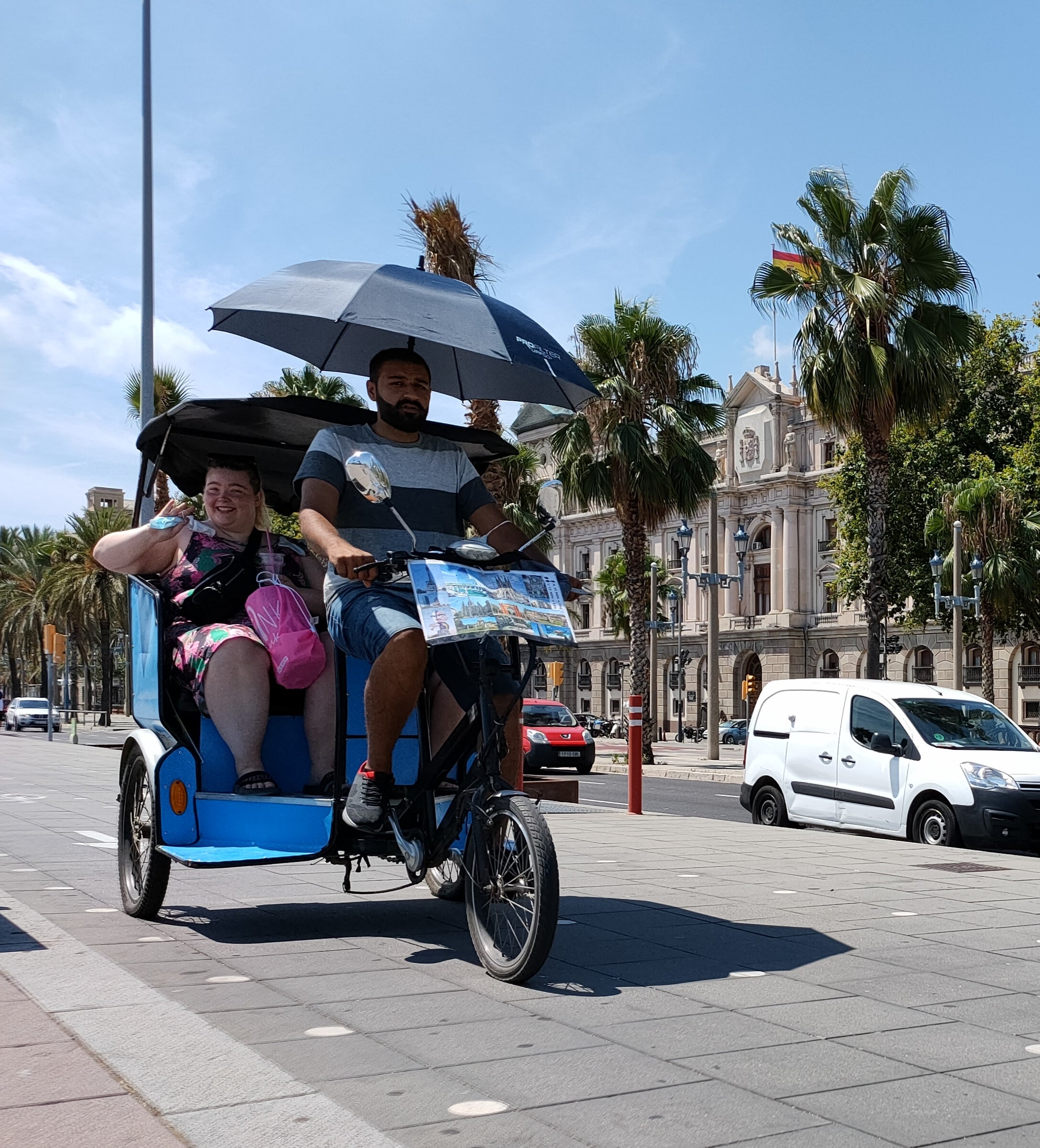 Un bicitaxi sense sostre ha hagut d'improvisar una cobertura amb paraigües / D.C.