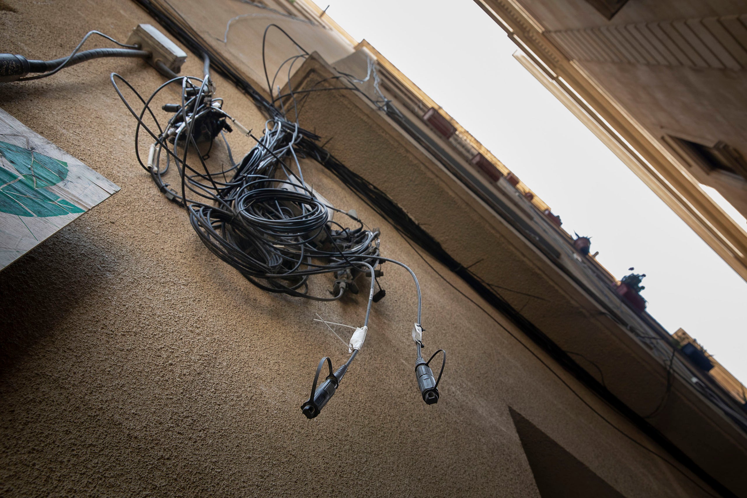 Cables despenjats del a xarxa de telecomunicacions en un carrer del Gòtic / Jordi Play