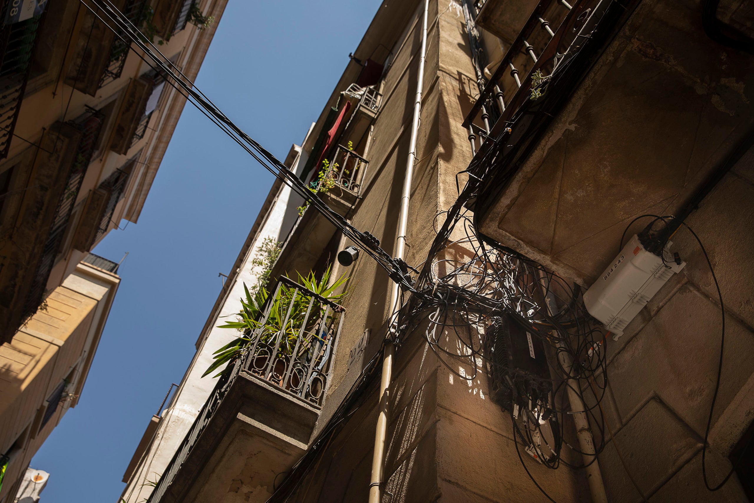 Cables, fils elèctrics i telefònics a les façanes d'un carrer de la ciutat / Jordi Play