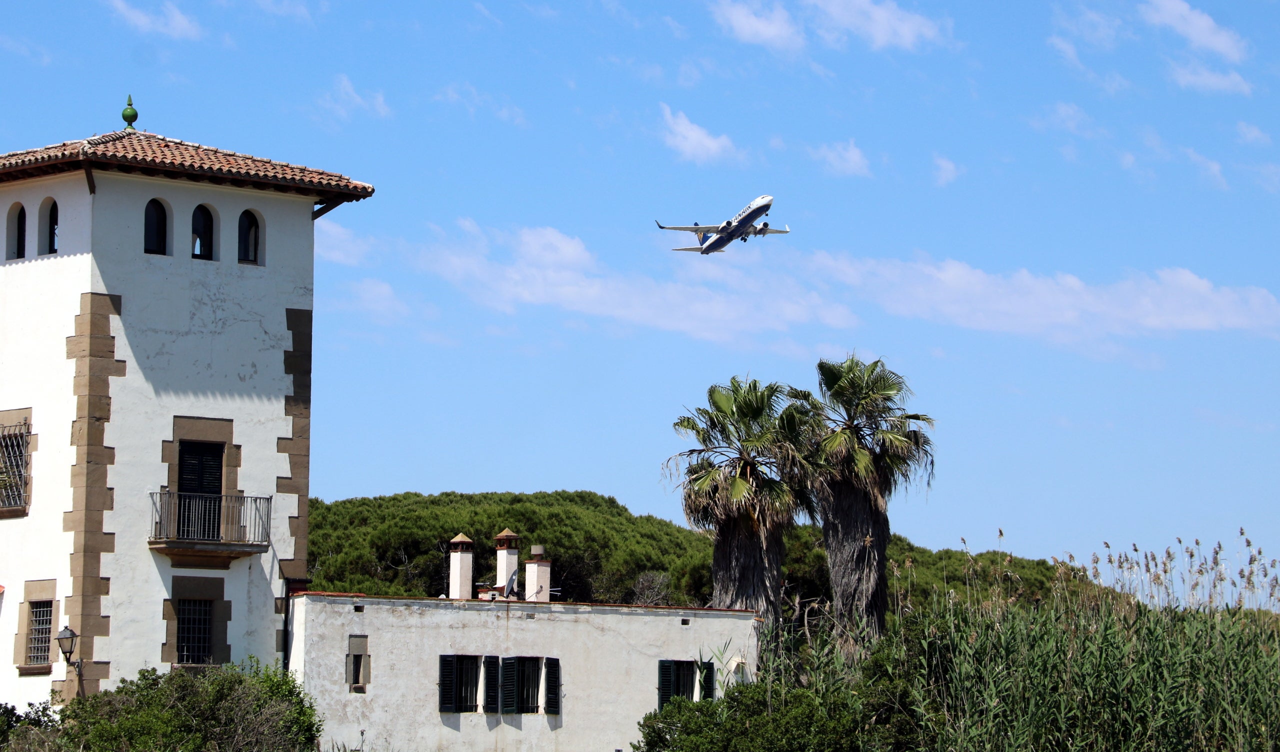 Un avió sobrevola una de les cases de la finca de La Ricarda, a tocar de l'estany, en una imatge d'arxiu