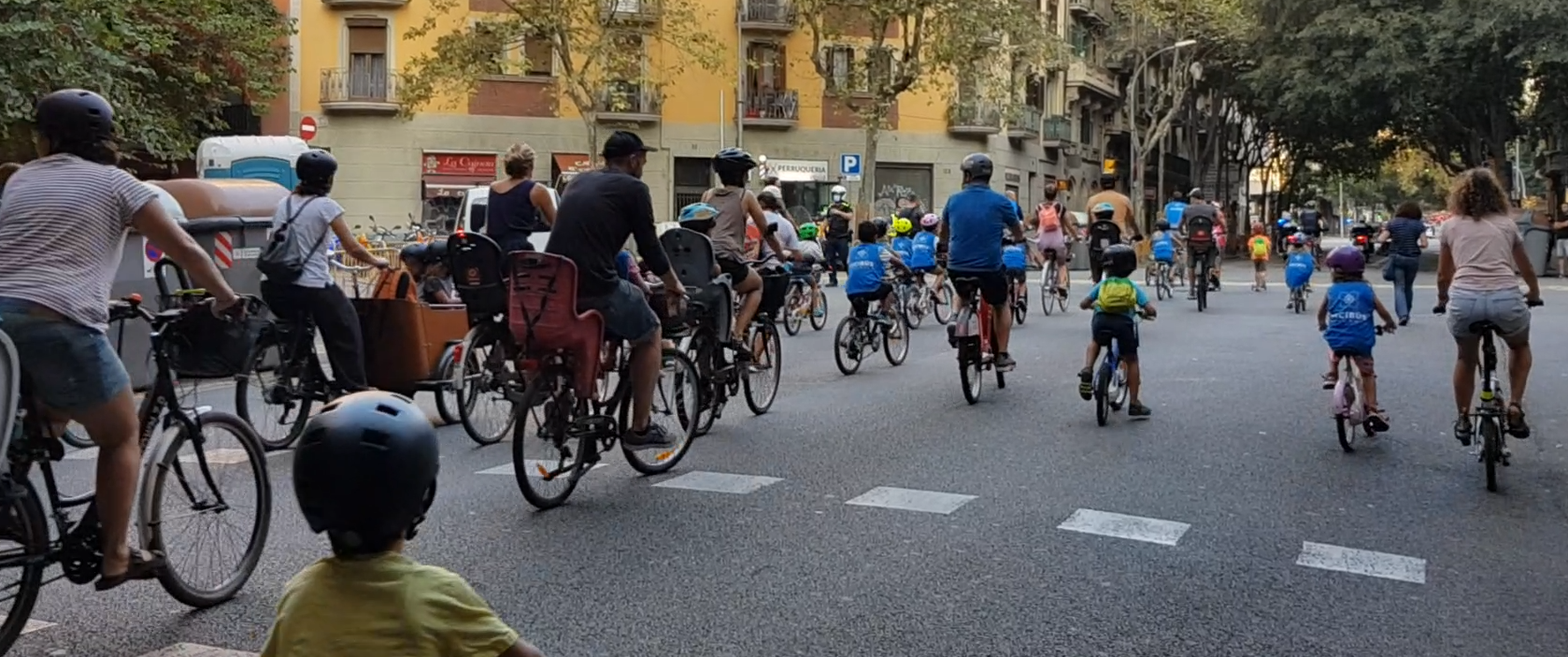 Famílies i menors dirigint-se en grup i en bicicleta a escoles de l'Eixample / Cedida