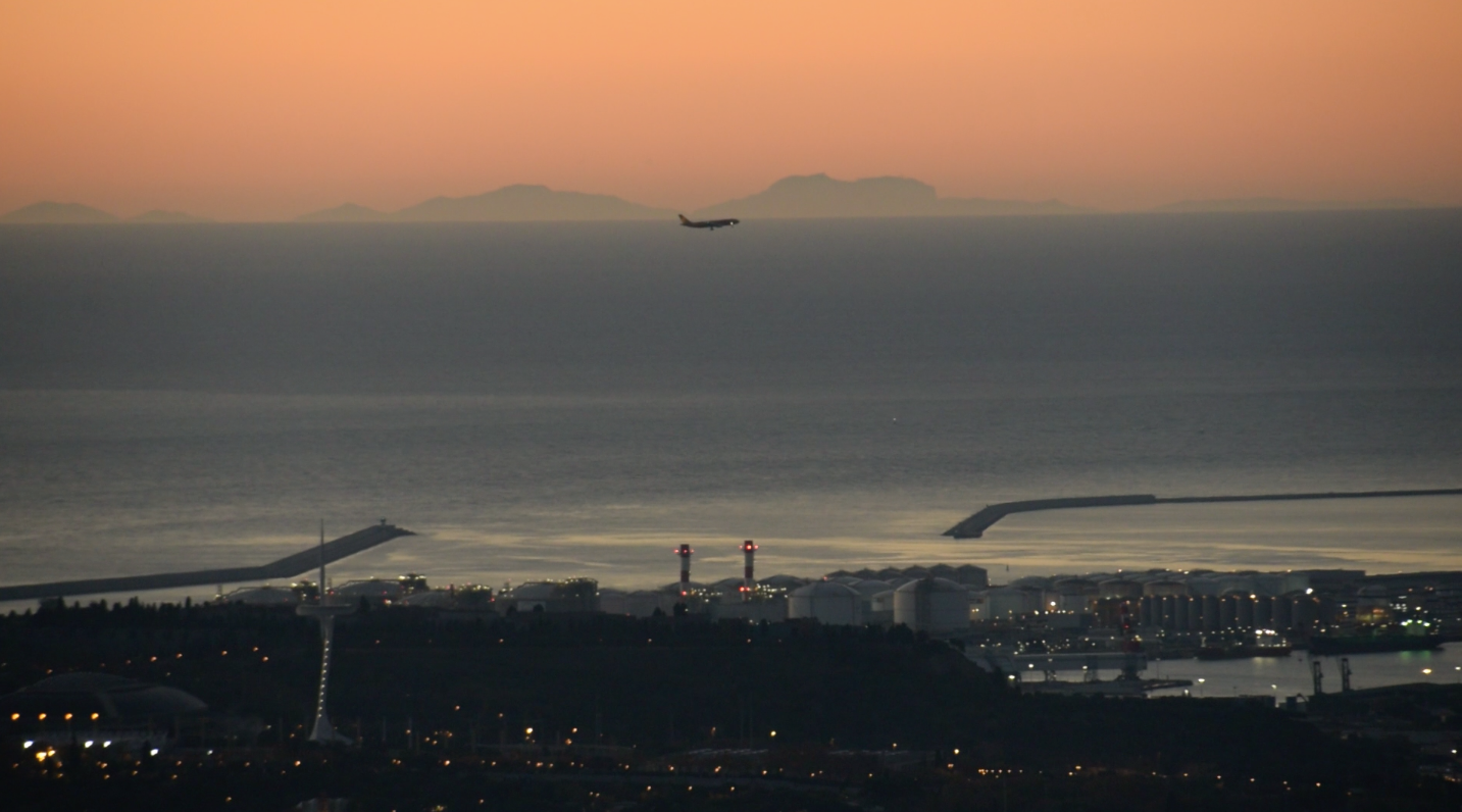 Un avió sobrevola Barcelona amb el perfil de Mallorca ben visible de fons / Alfons Puertas