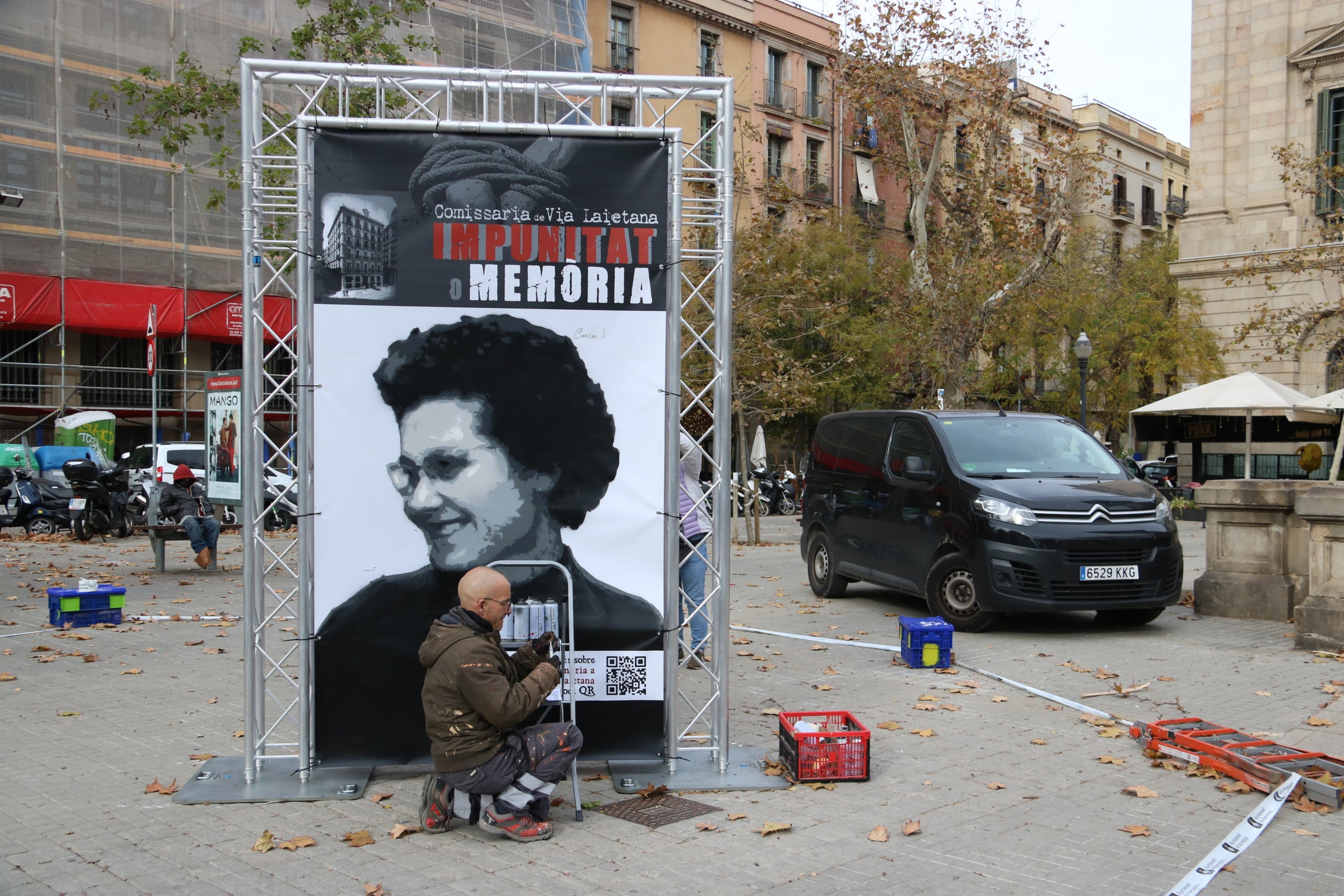 L'artista Rock Blackblock treballant en el mural 'Impunitat o memòria' sobre la comissaria de Via Laietana / Pau Cortina / ACN