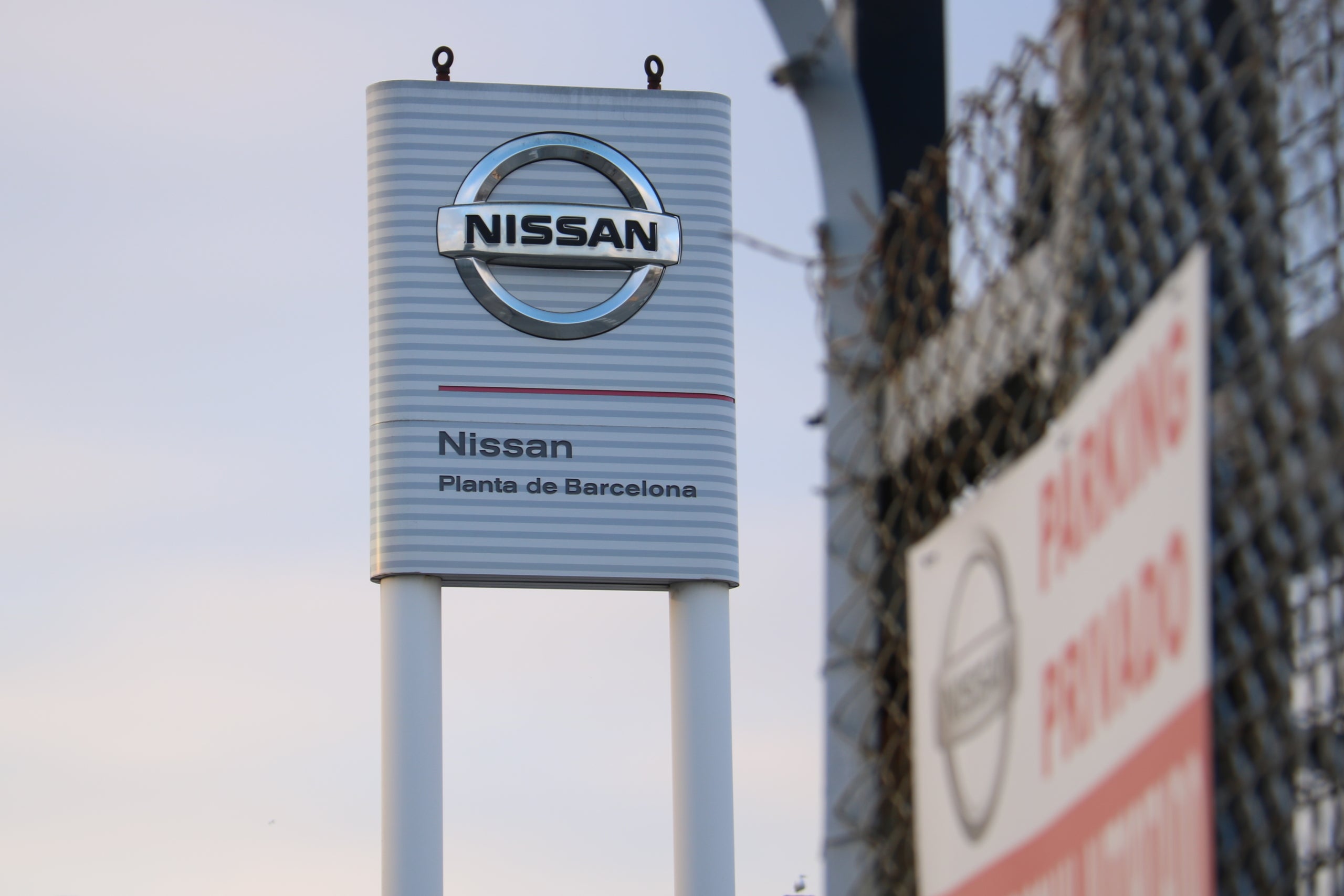 Reixat de la planta de Nissan a la Zona Franca amb l'emblema de la marca de fons, el 16 del desembre del 2021 / Aina Martí (ACN)