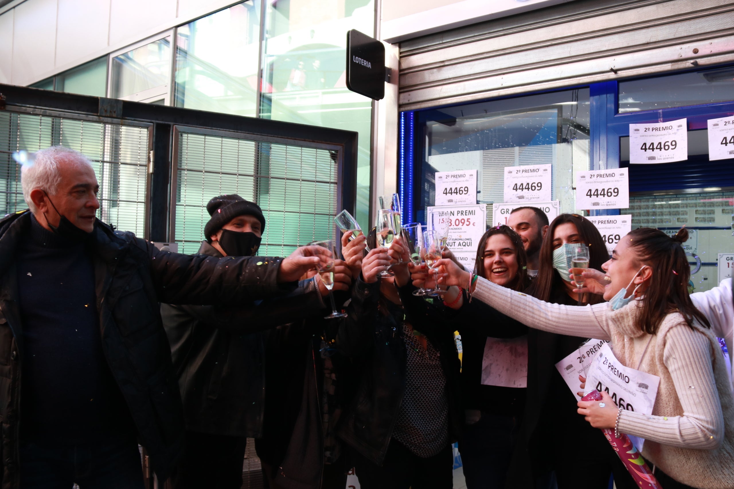 Treballadors de l'administració de loteria del centre comercial Arenas de Barcelona bridant després d'haver repartit el segon premi del sorteig de Reis / Albert Cadanet / ACN