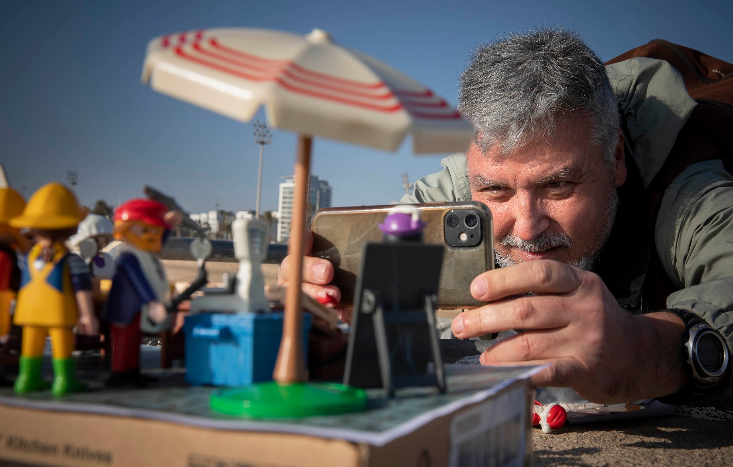 Paco Torres fotografiant ninos de Playmobil a l'espigó de Bac de Roda, a Barcelona / Jordi Play