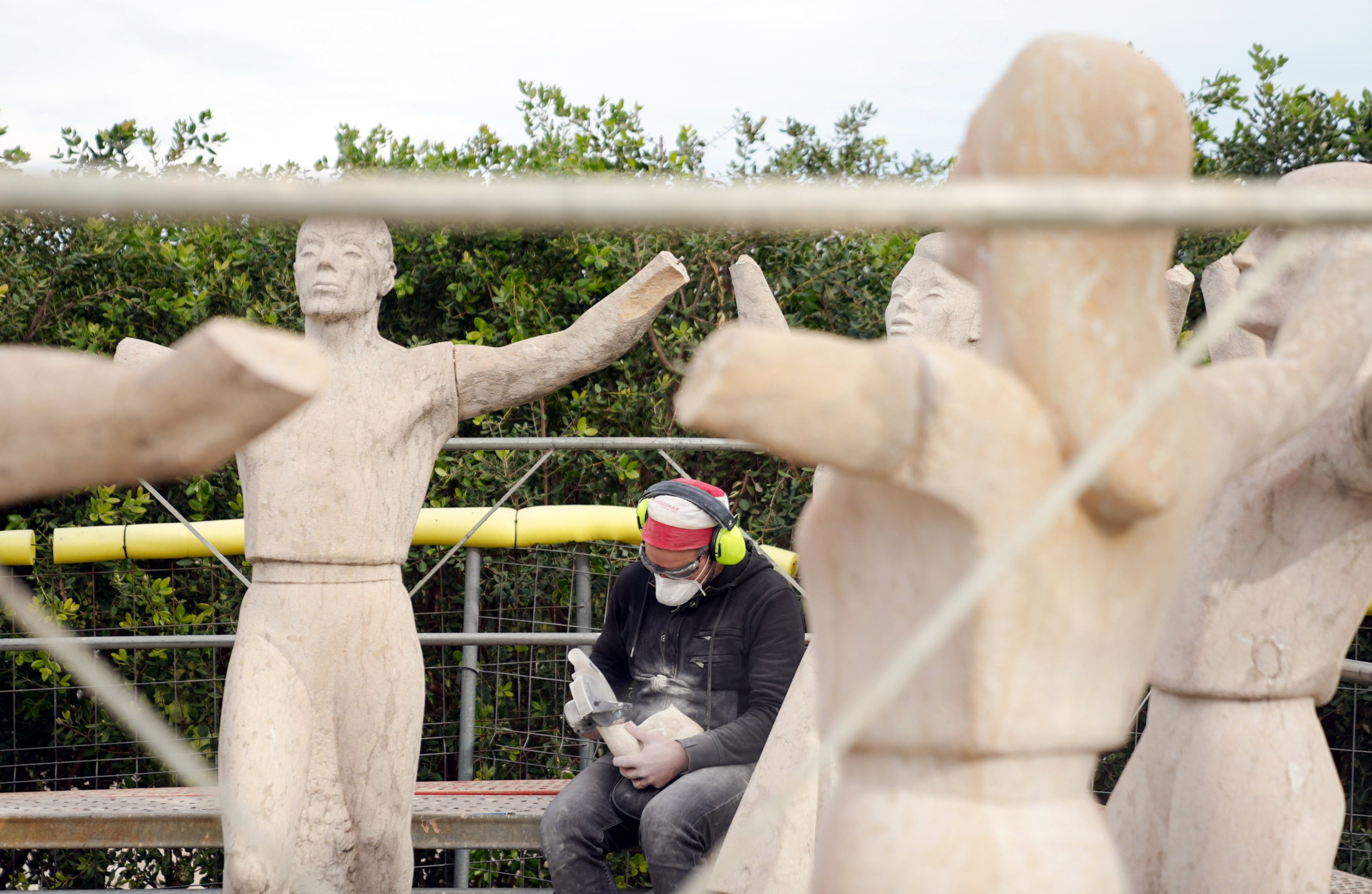 L'escultura La Sardana de Barcelona amb les mans que els falten i un treballador de les obres de reparació / Ajuntament de Barcelona