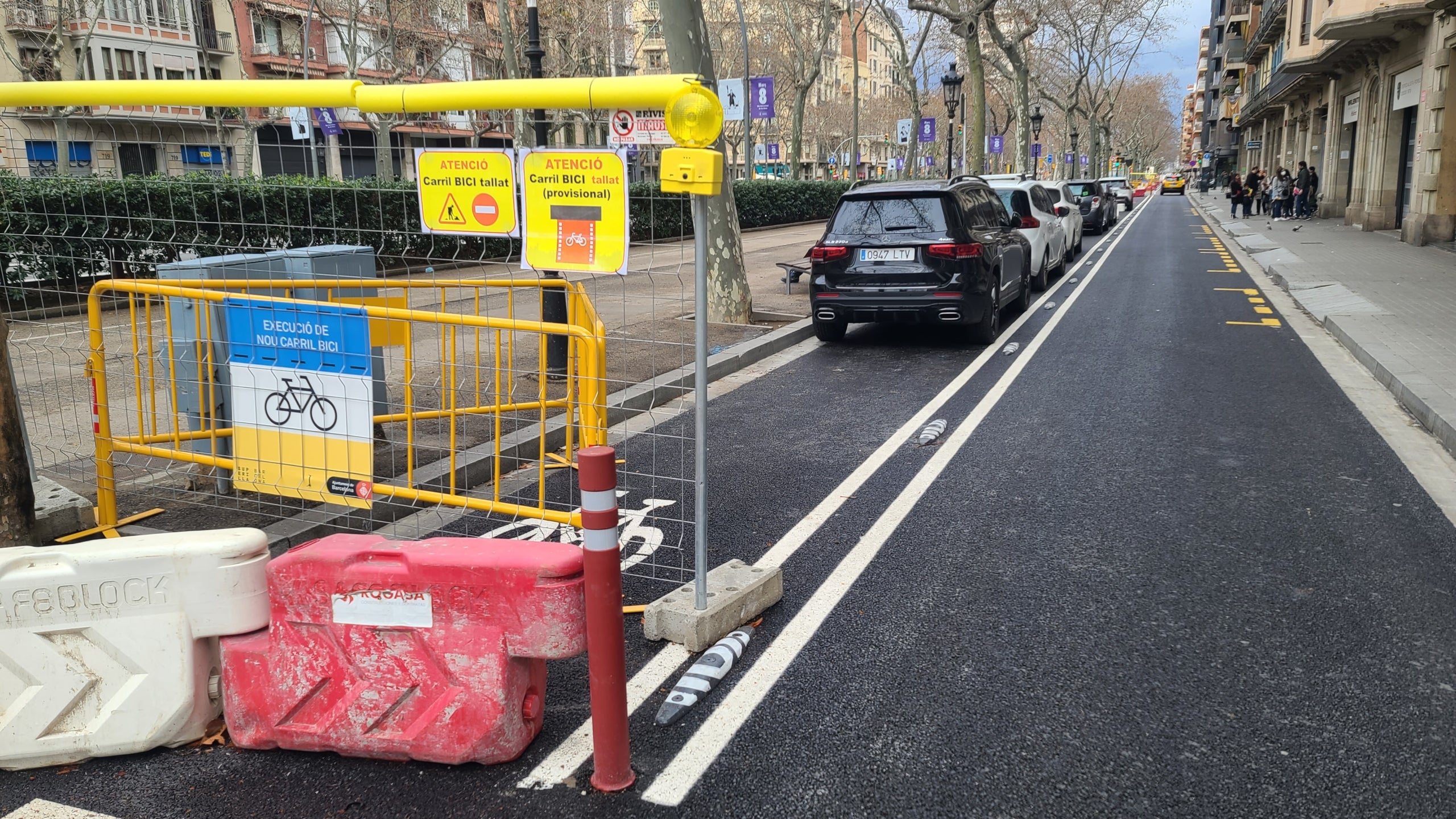 Un grup de persones fa servir el 6 de març de 2022 un carril bici en obres a la Gran Via com a pàrquing improvisat / ESM