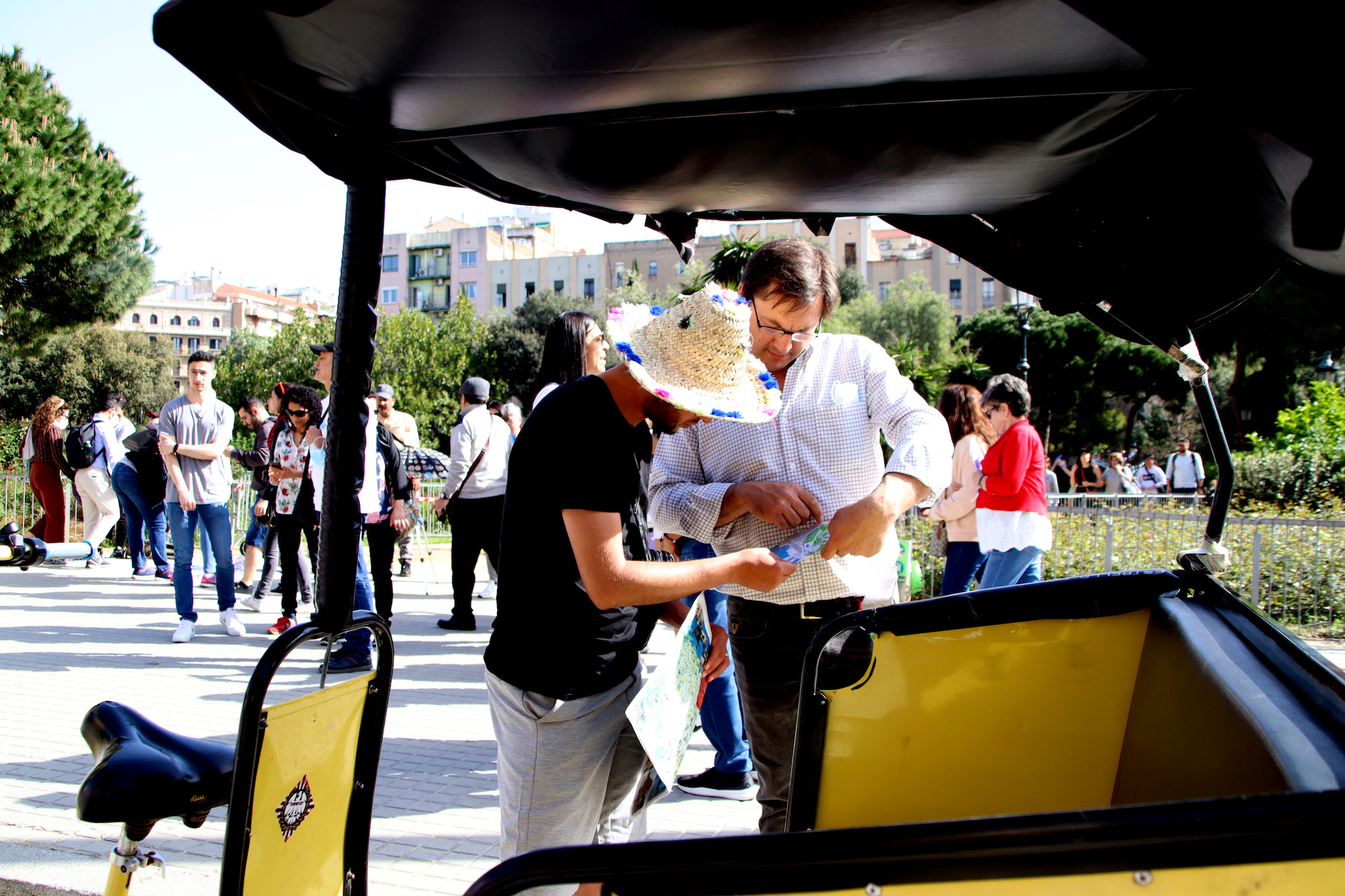 Un turista conversa amb el conductor d'un bicitaxi a Barcelona / ACN