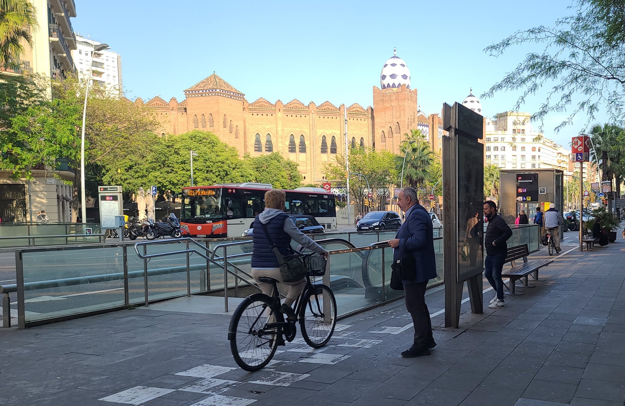 Un vianant ha d'esperar per accedir al metro, mentre un ciclista passa pel carril bici del carrer de la Marina, ignorant els senyals que indiquen que ha de cedir el pas / ESM