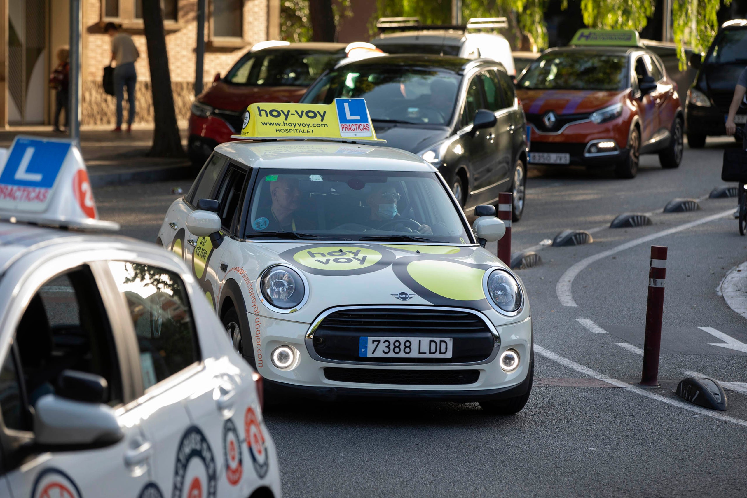 Cotxes d'autoescola pels carrers del districte de Sants-Montjuïc. Aprendre a conduir, conducció, cotxes.