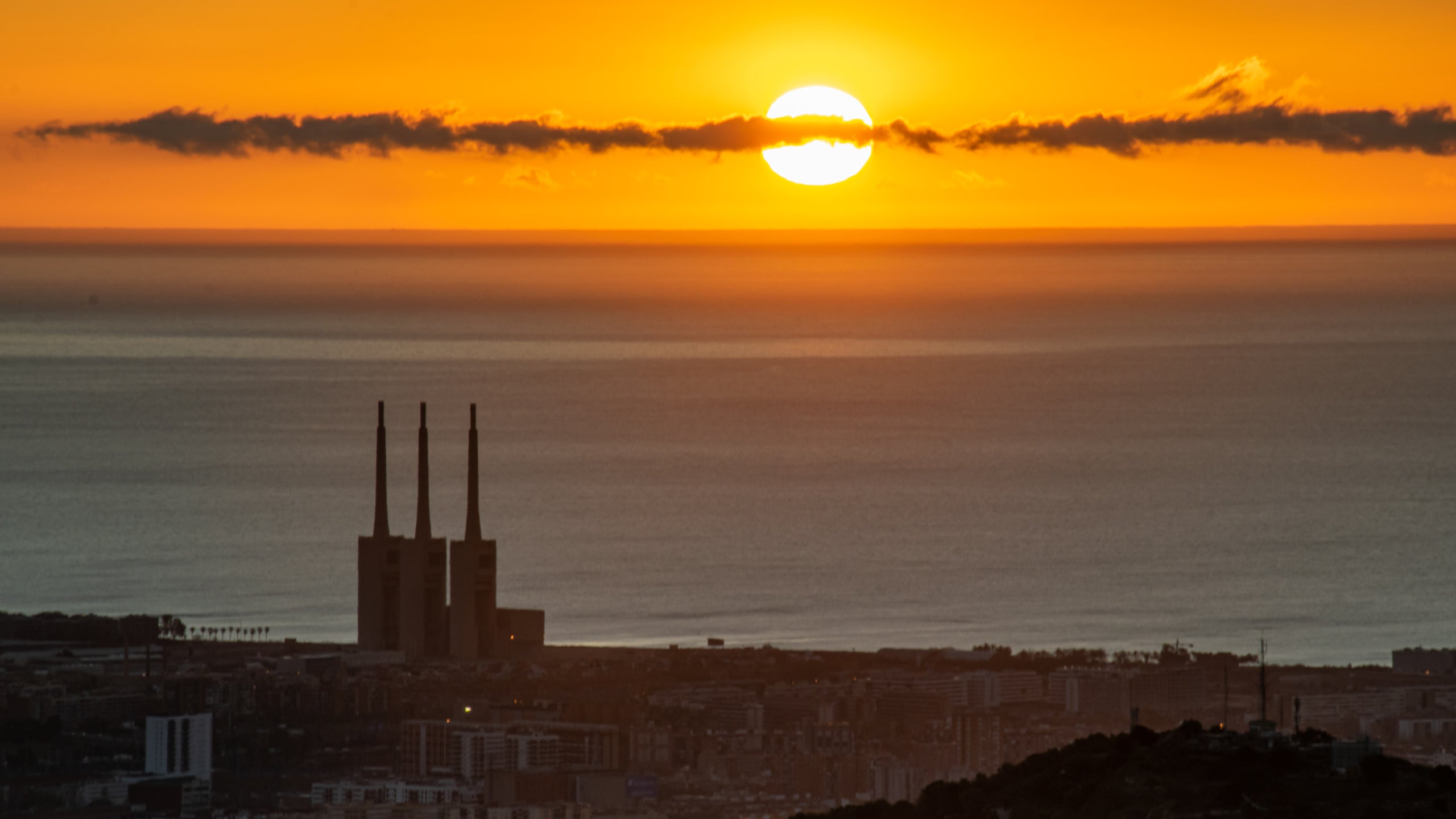 La sortida del sol d'aquest dilluns amb aquest feix de núvols creuant el sol / Alfons Puertas (Observatori Fabra)