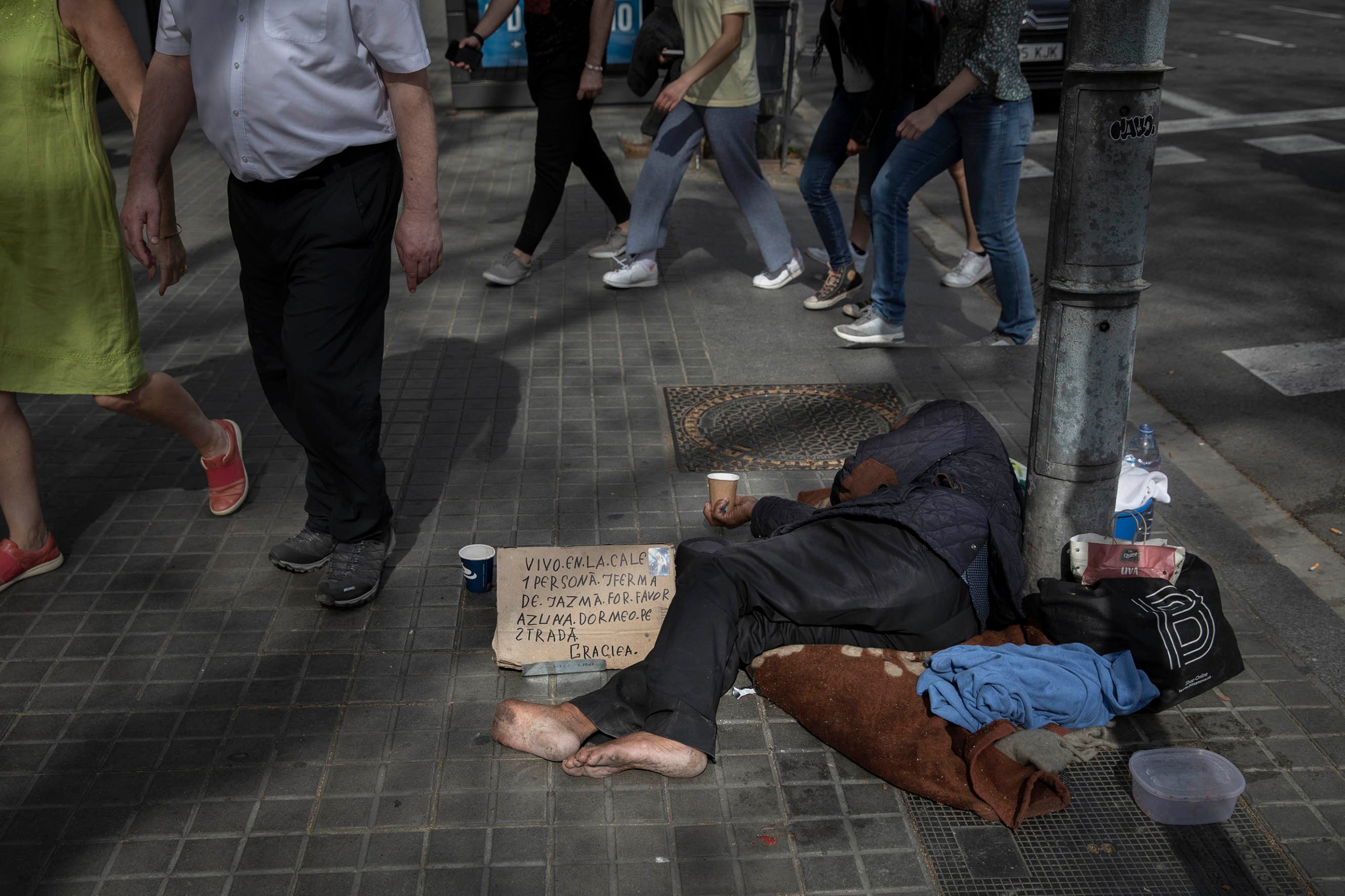 Una persona sense sostre a la plaça d'Urquinaona en una imatge d'arxiu / Jordi Play