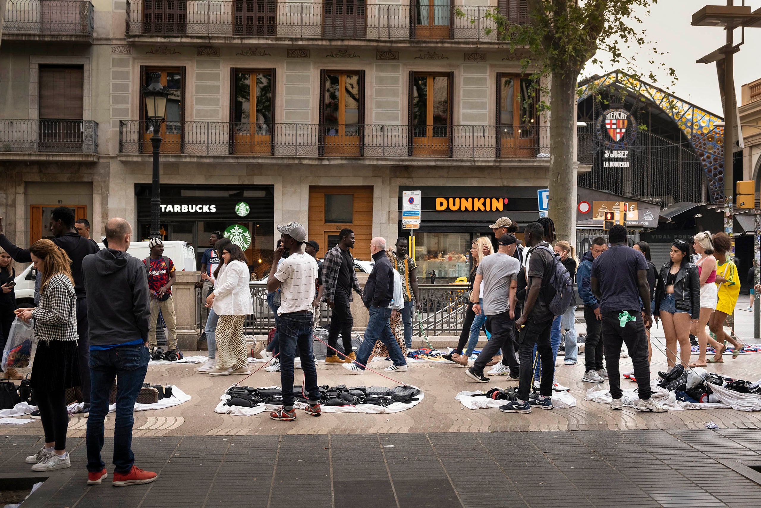 Venda de manters TOP MANTA a Les Rambles davant la boqueria, venda il.legal, articles de luxe falsificats, falsos,