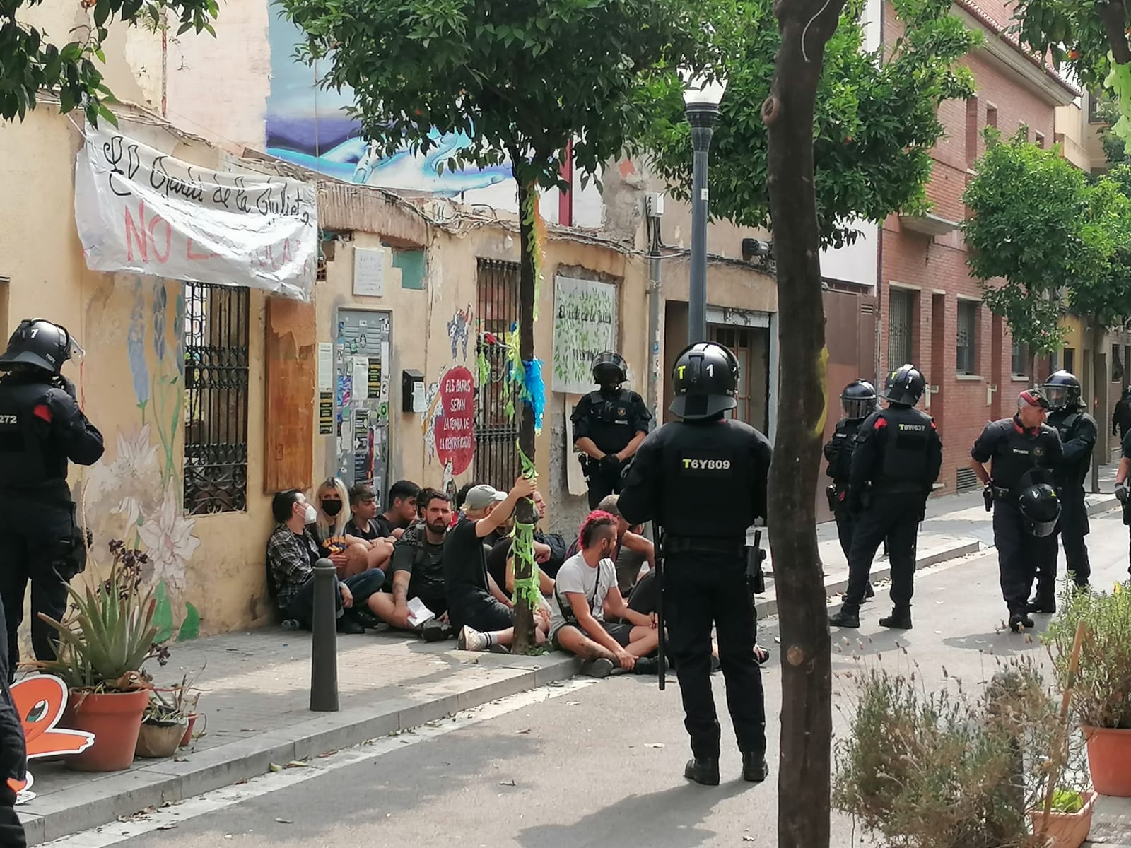Diferents persones bloquejant la porta de l'hort comunitari / Gabriel González