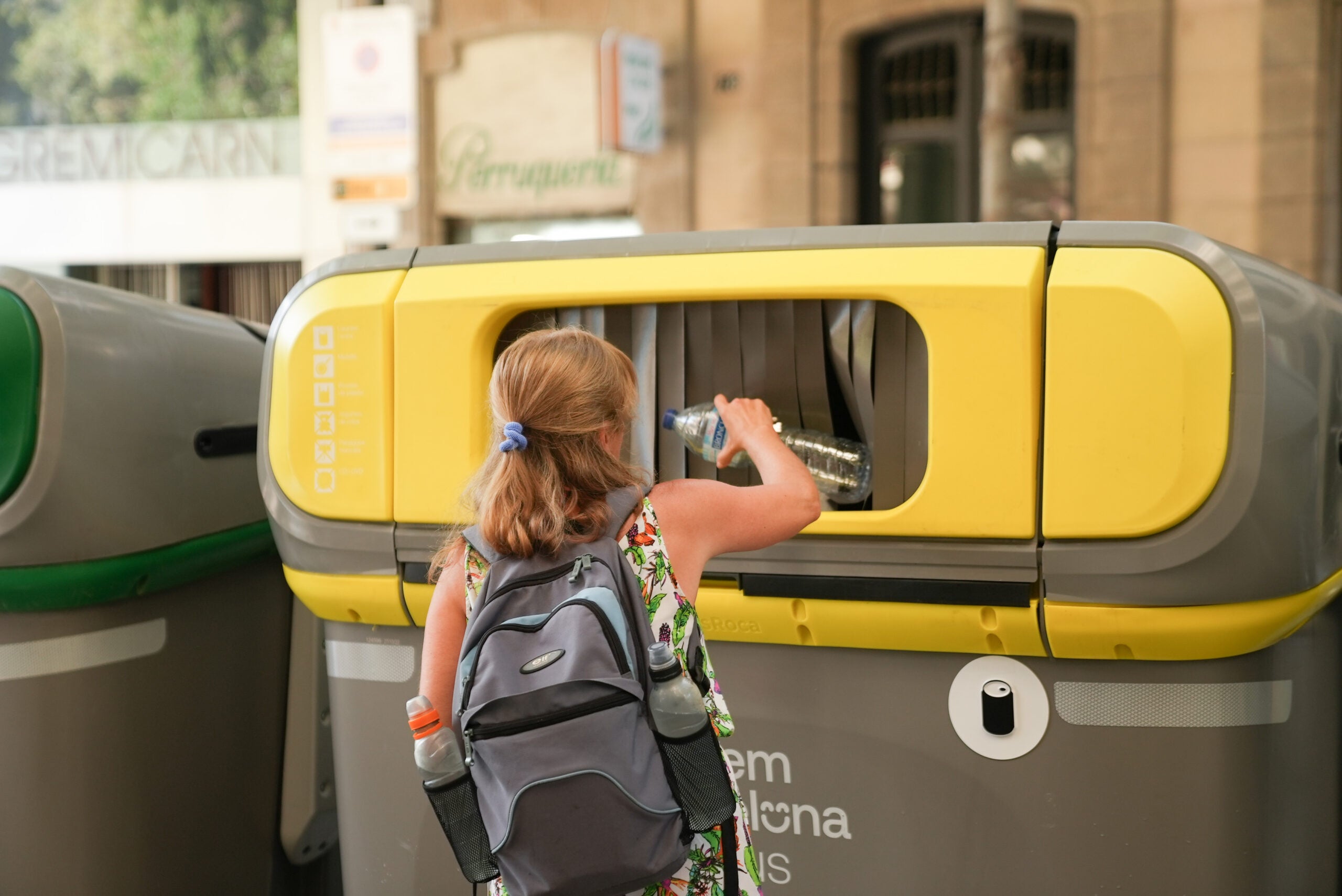 Una persona llançant una ampolla de plàstic en un contenidor | Ajuntament