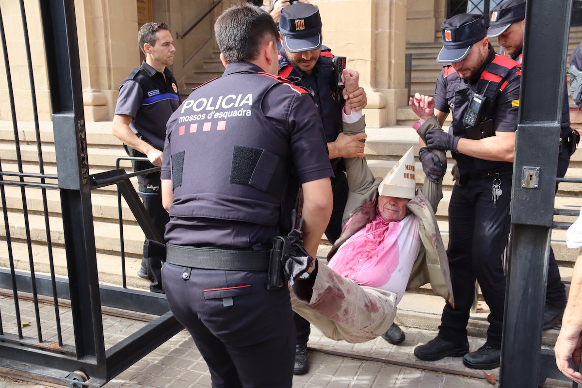 Dos dels activistes a la seu del Ministeri de Defensa de Barcelona, simulant que estan tacats de sang / ACN
