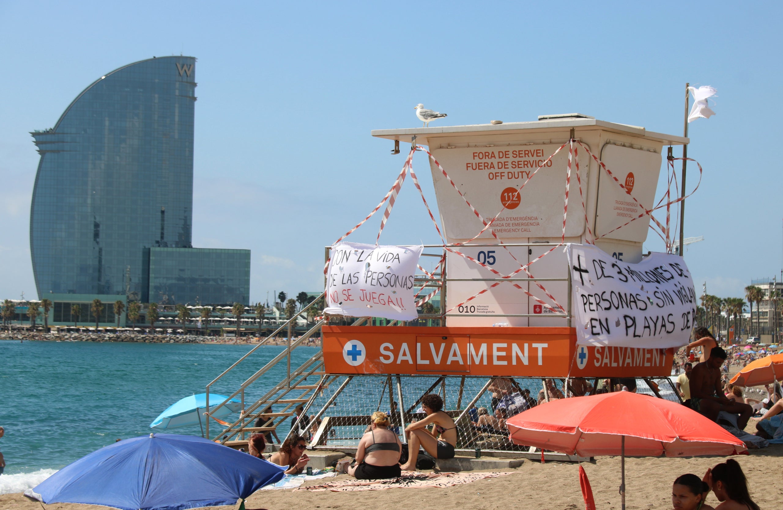 Una torre de vigilancia de la playa de la Barceloneta fuera de servicio y con carteles reivindicativos por la huelga de socorristas | Norma Vidal (ACN)