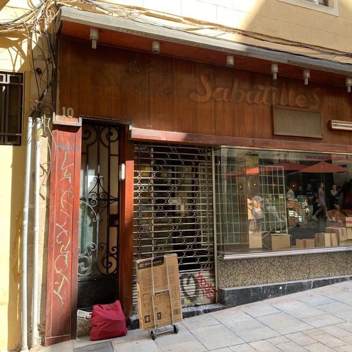 L'emblemàtica Casa de les Sabatilles amb la persiana tancada a l'antic local de la baixada de la Llibreteria / Casa de les Sabatilles