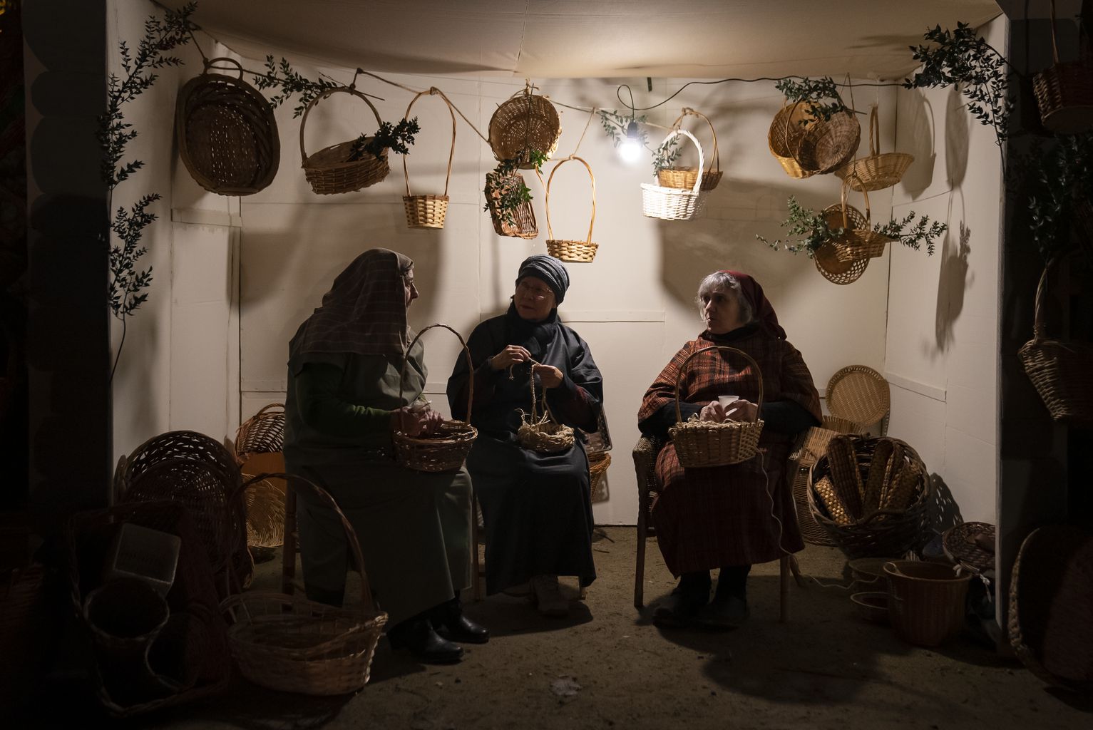 Representació de tres dones fabricant cistells de vímet dins el Pessebre Vivent de la Marina AJUNTAMENT