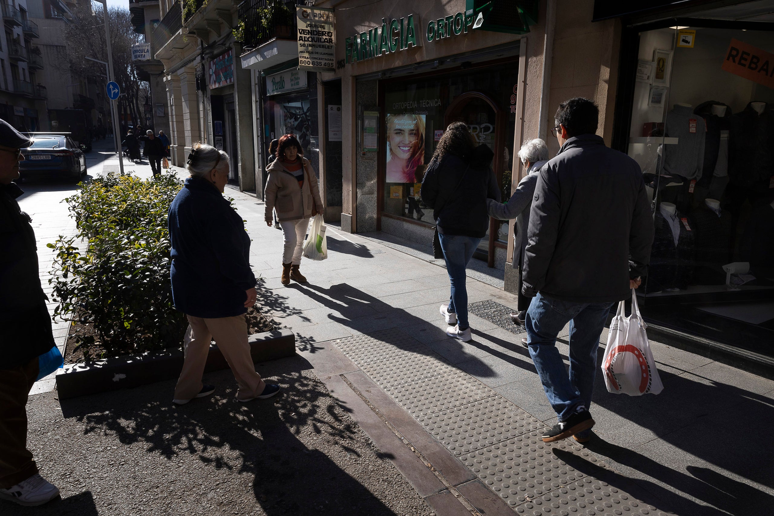 Veïns passegen amb bosses al carrer Gran de Sant Andreu | JORDI PLAY