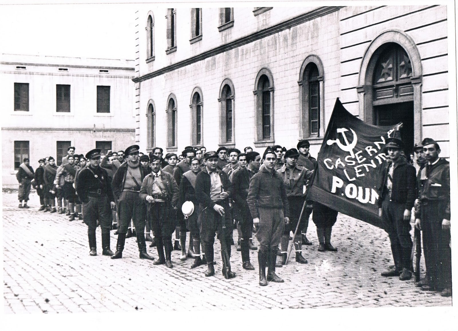 Manuel Barceló i Cabanes, el primer de l'esquerra del grup ubicat en primer pla, comparteix fotografia amb George Orwell, el personatge més alt que sobresurt al fons de la imatge / Agustí Centelles (26 de desembre del 1936)