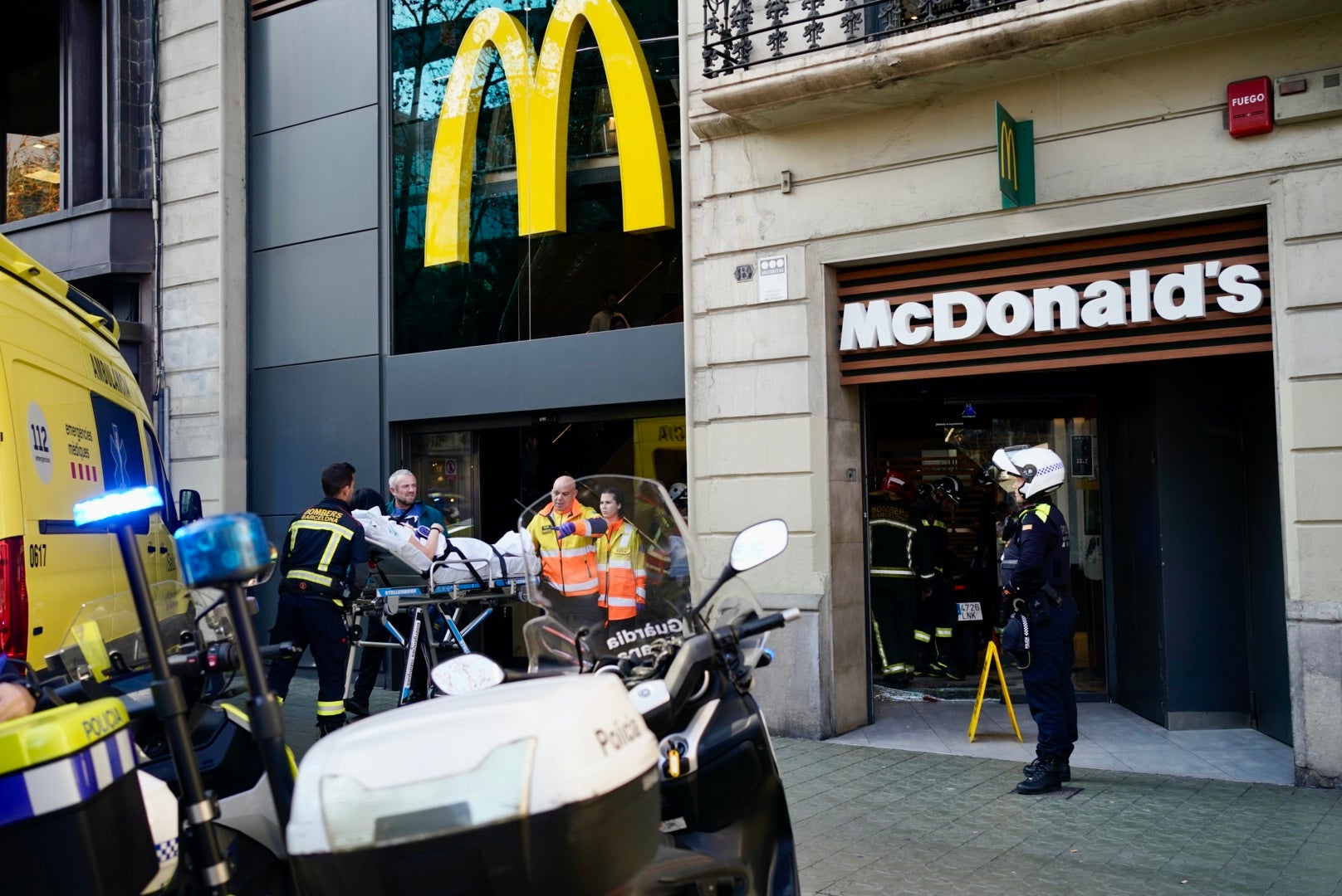 Una ambulància del SEM s'emporta un dels dos ferits pel xoc d'una moto amb la façana del McDonald's / Mireia Comas