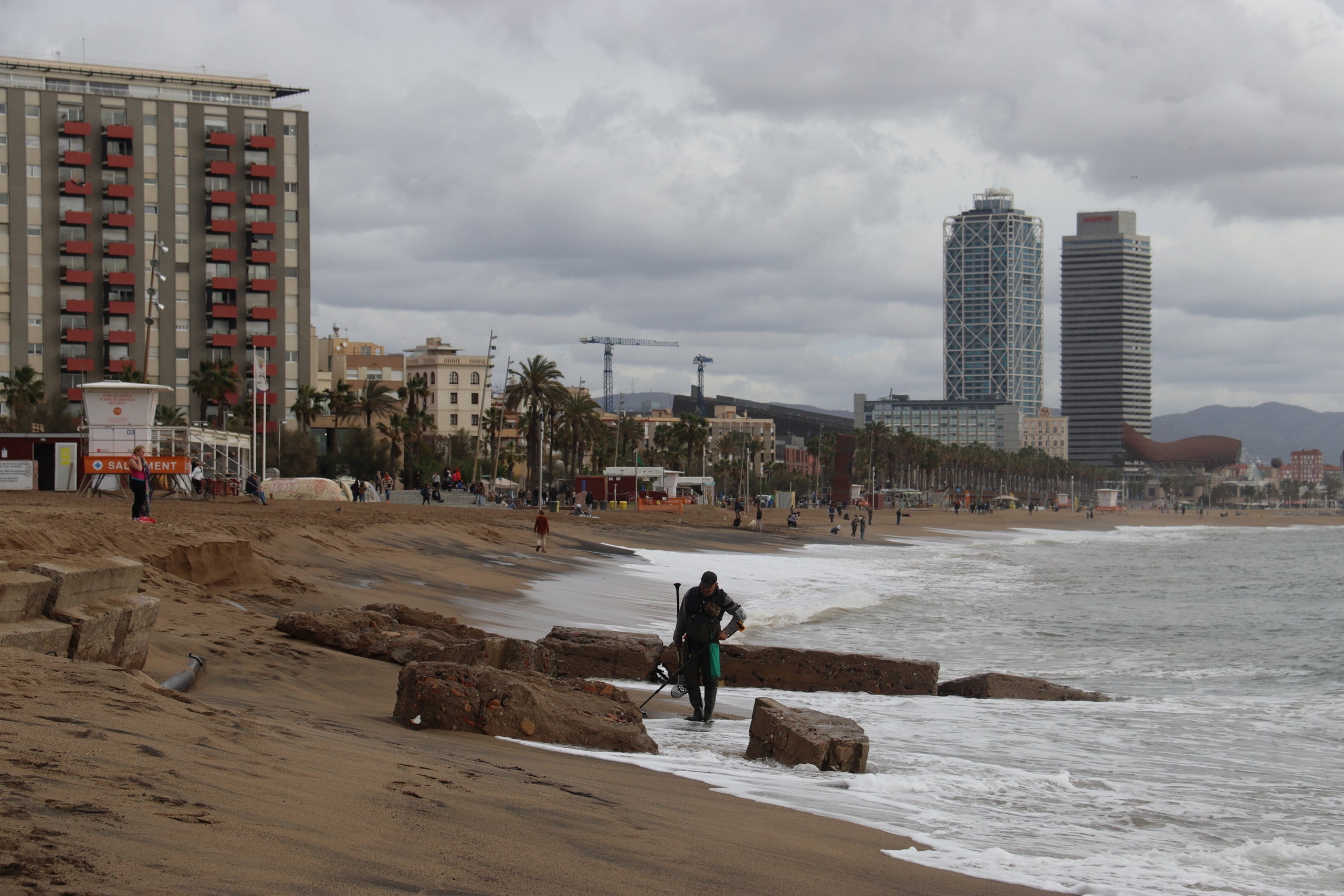 Una persona passeja per la platja de Sant Sebastià després del temporal / ACN