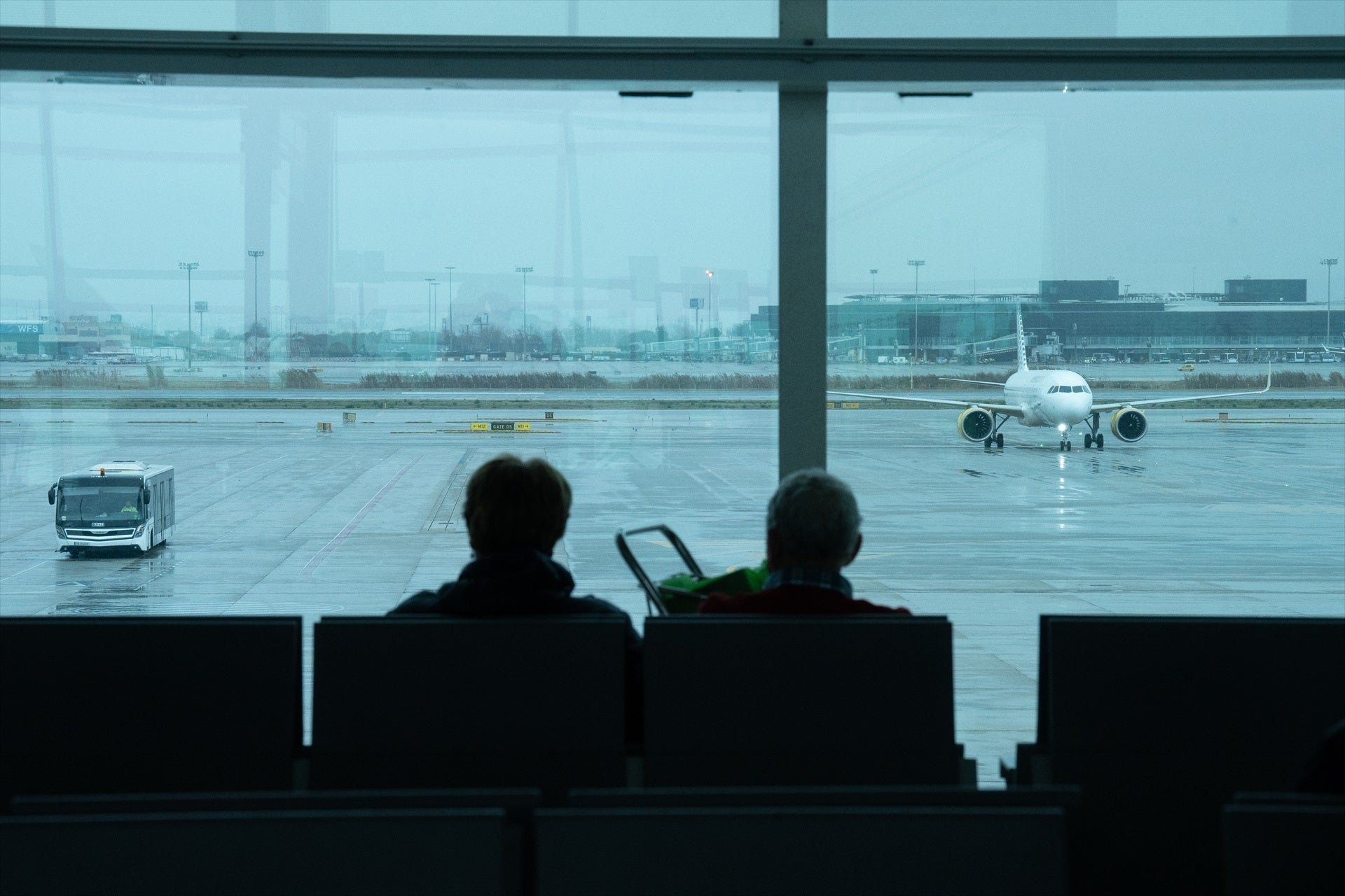 Dos persones esperen el seu vol a l'aeroport del Prat / Europa Press