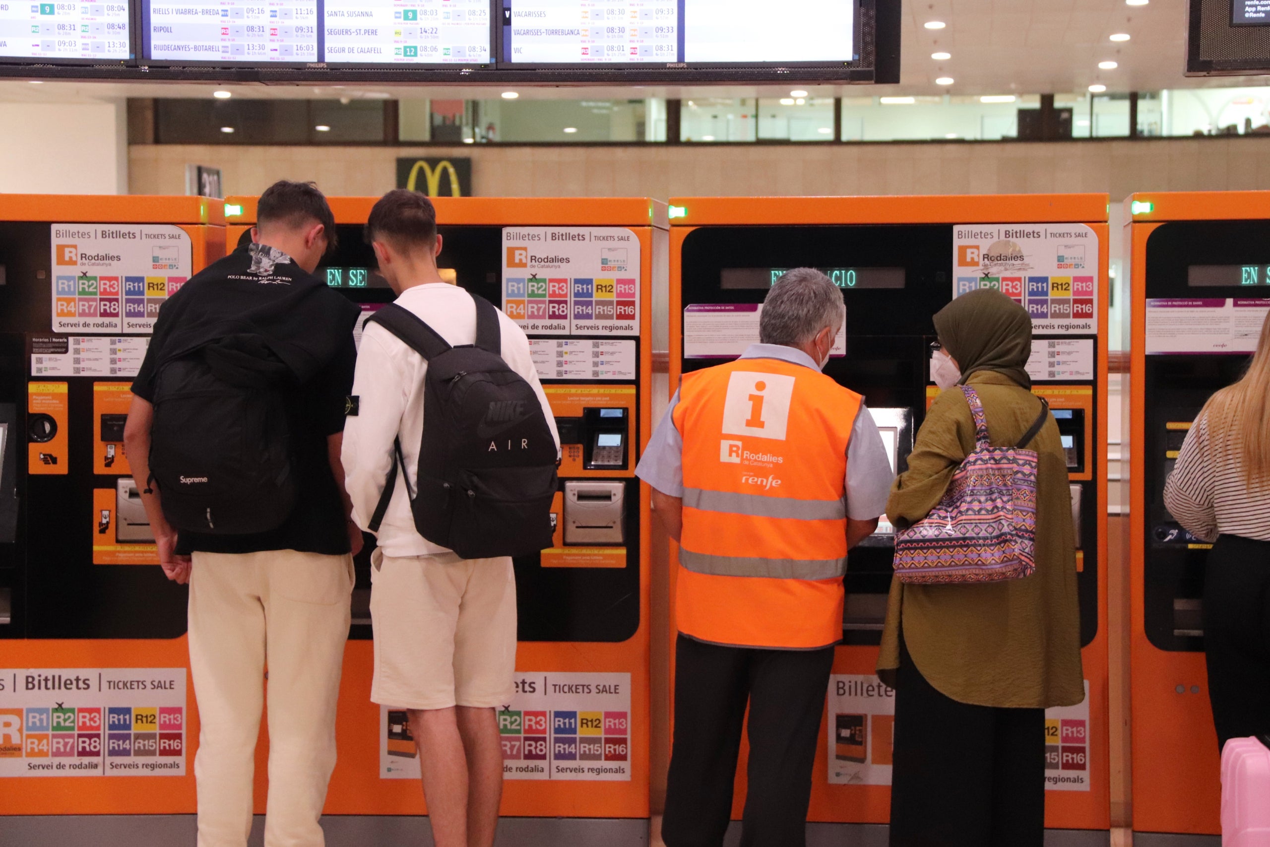 Diverses persones a les màquines d'autovenda de Rodalies de l'estació de Sants de Barcelona el primer dia en vigor dels abonaments gratuïts | Maria Asmarat (ACN)