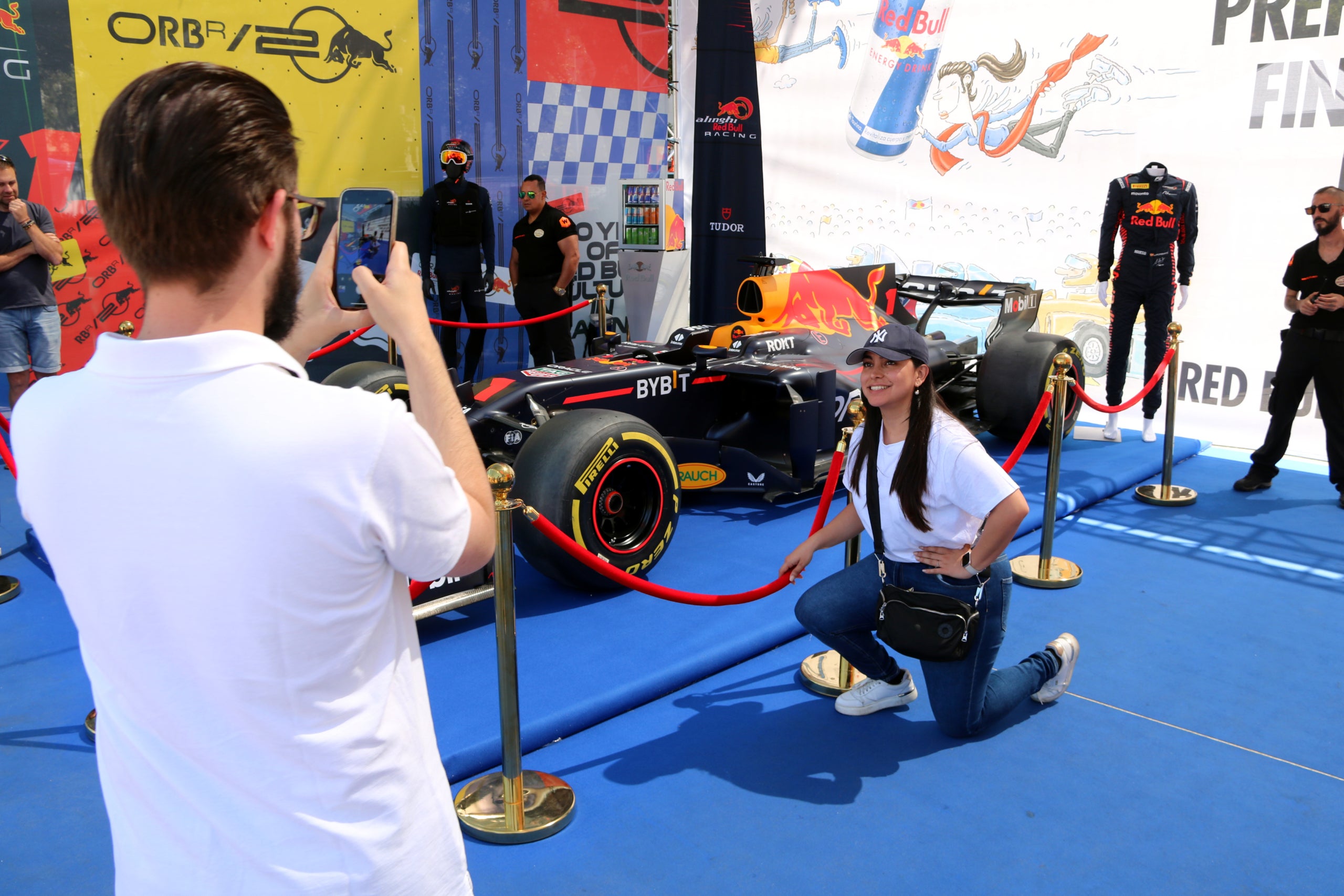 Una aficionada es fotografia amb un monoplaça d'F1 al Fan Village de plaça de Catalunya / ACN