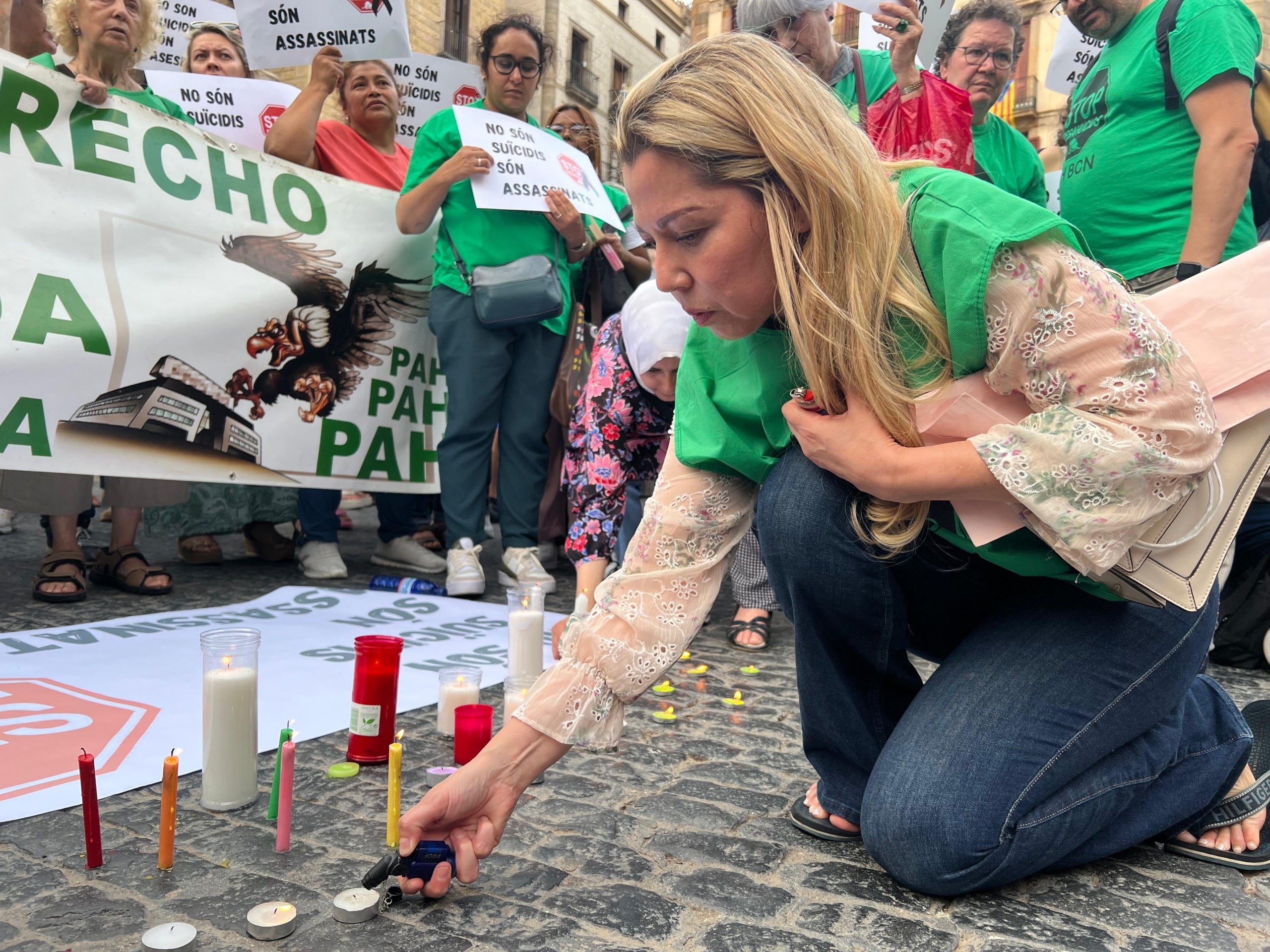 Una dona encén espelmes per recordar dues germanes que es van suicidar hores abans de ser desnonades en una protesta d'entitats a favor del dret a l'habitatge a la plaça Sant Jaume de Barcelona / ACN (Norma Vidal)