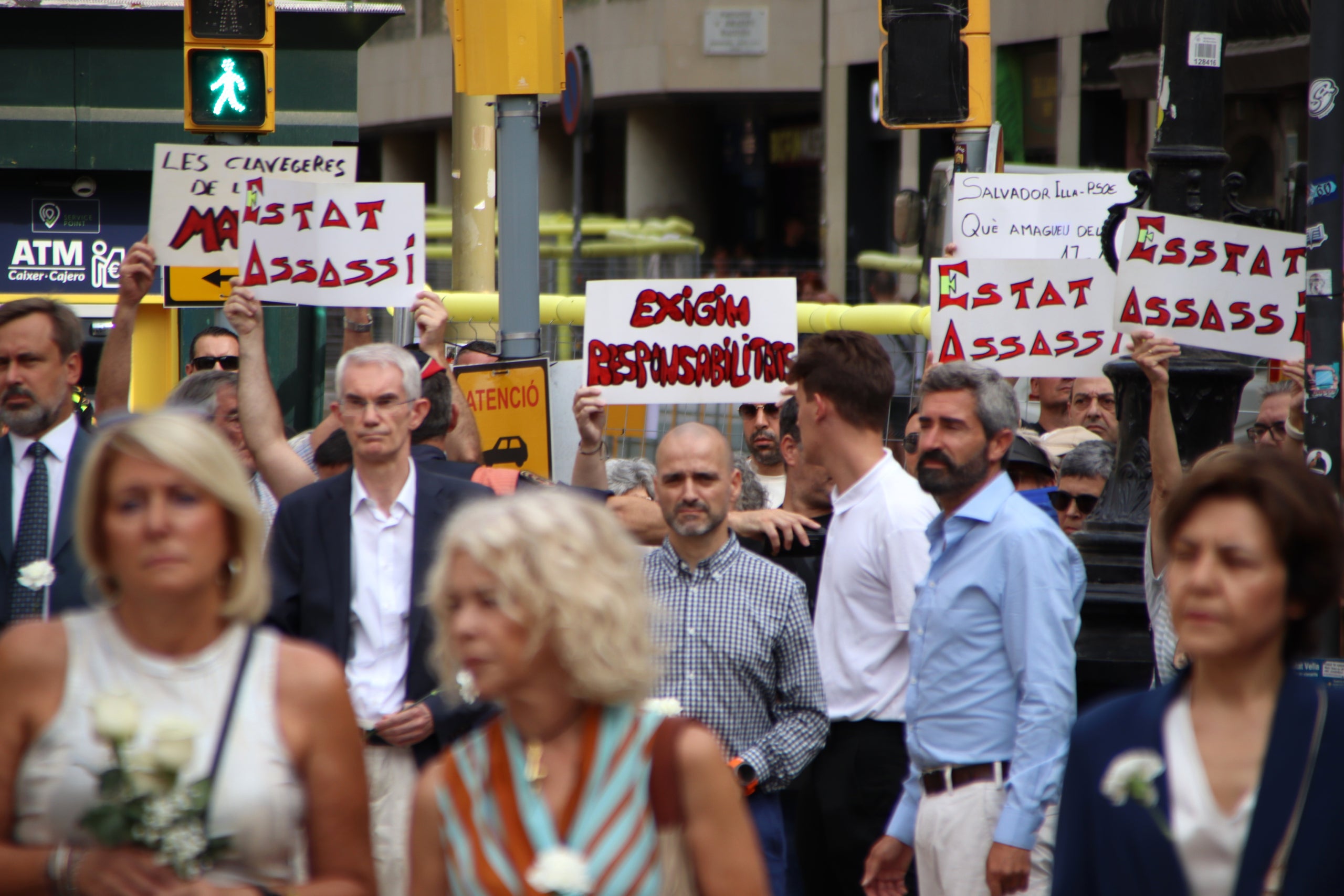 Algunes persones al marge de l'acte oficial mostren cartells de protesta / Blanca Blay / ACN