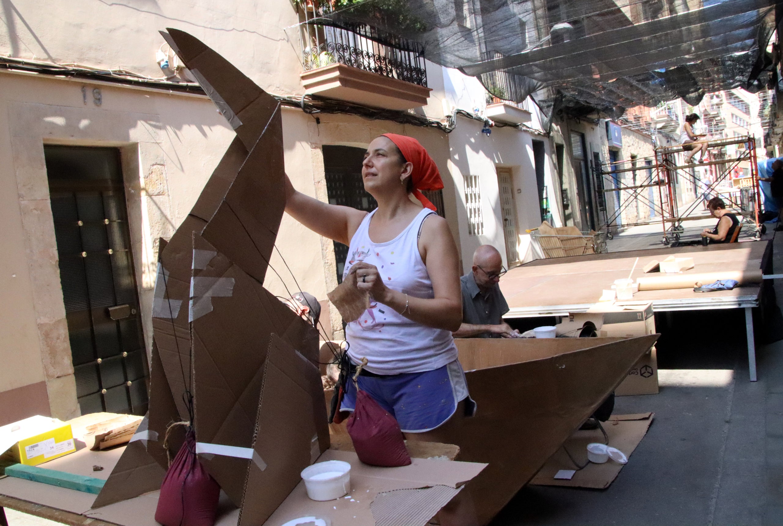Una vecina de la calle Fraternidad acabar de guarnir su calle / ACN