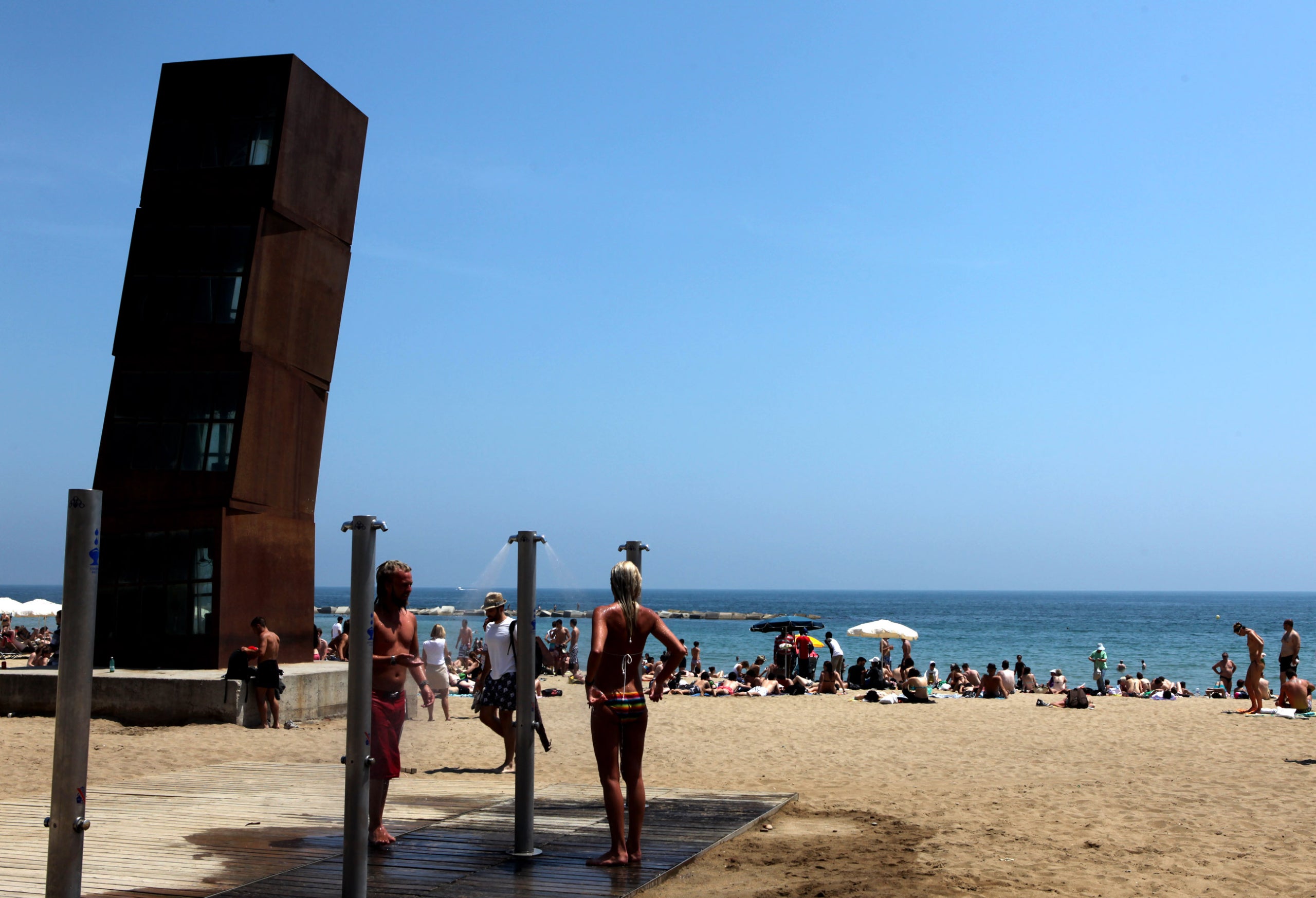 Banyistes dutxant-se a les dutxes públiques de la platja de la Barceloneta / ACN