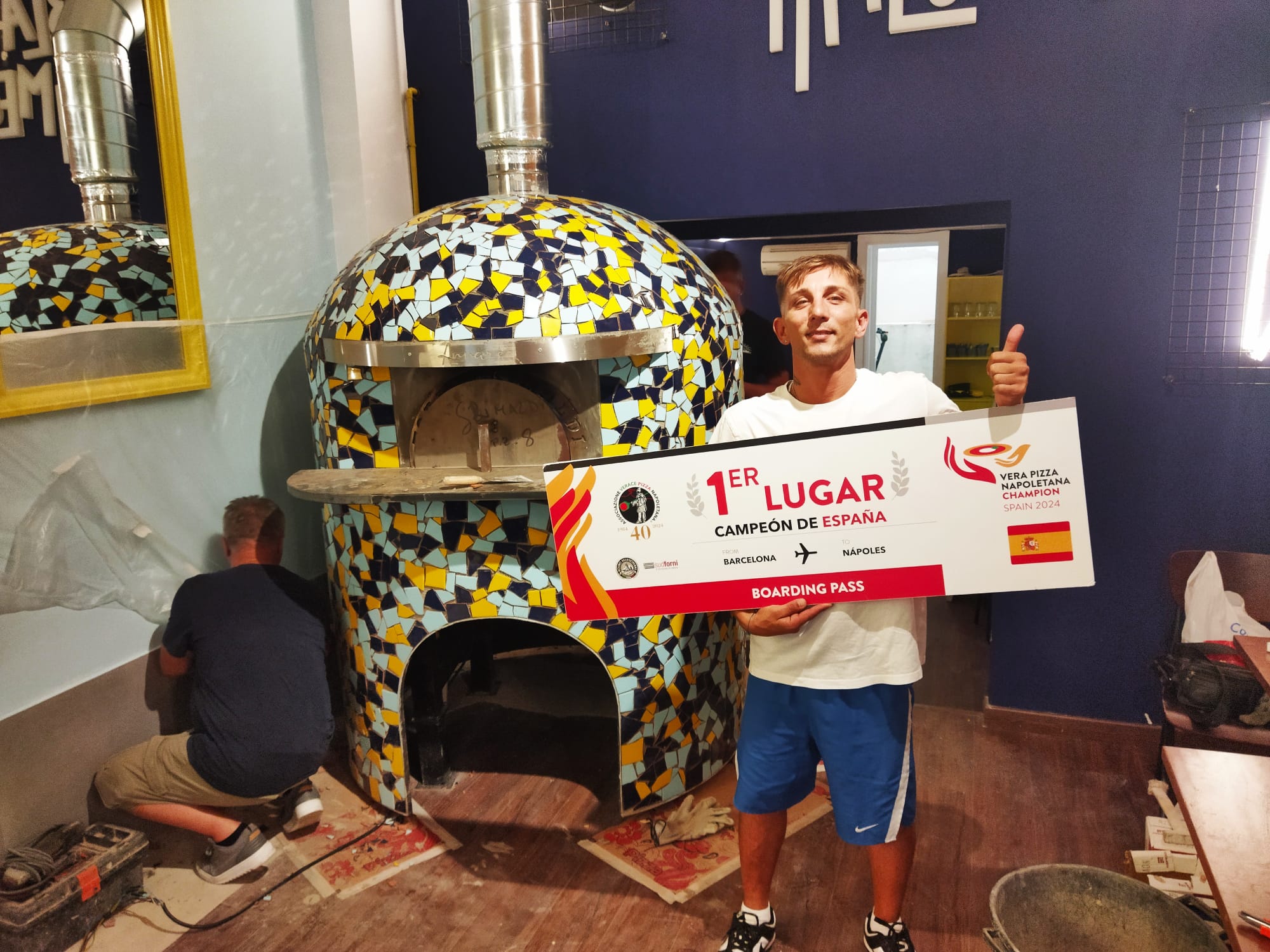 Salvatore Ambrosino, davant del forn en construcció del seu establiment i el premi que l'acredita com el millor pizzer de pizza napolitana de tot l'Estat / Jordi Subirana