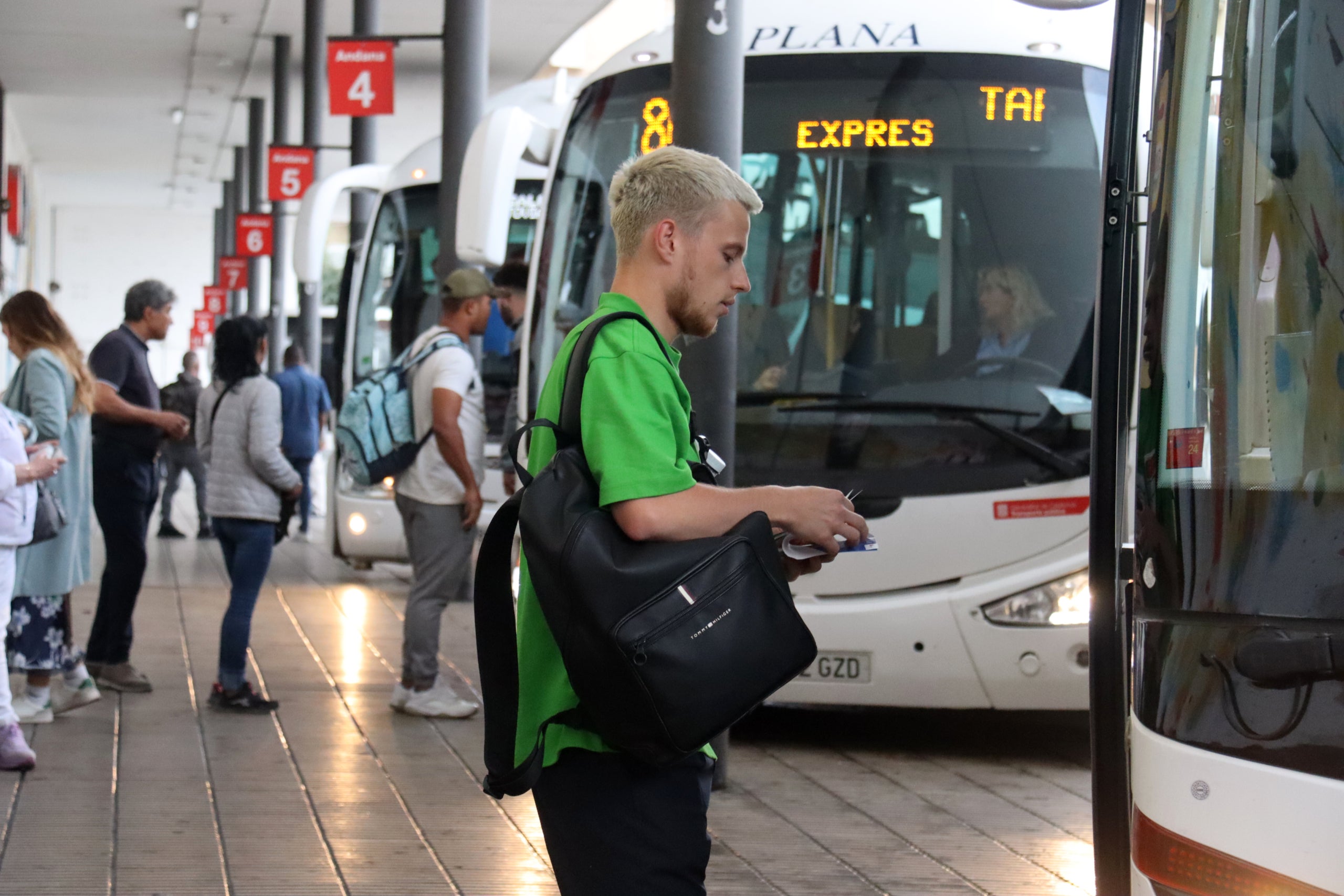 Un noi agafant la targeta T10120 abans d'entrar al bus que surt de Tarragona i va directe a Barcelona | Neus Bertola (ACN)