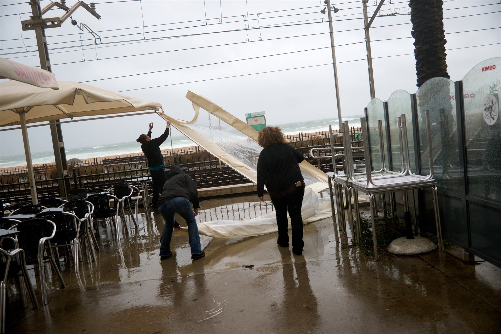 Trabajadores de un restaurante del paseo marítimo de Badalona se preparan para un temporal / Europa Press