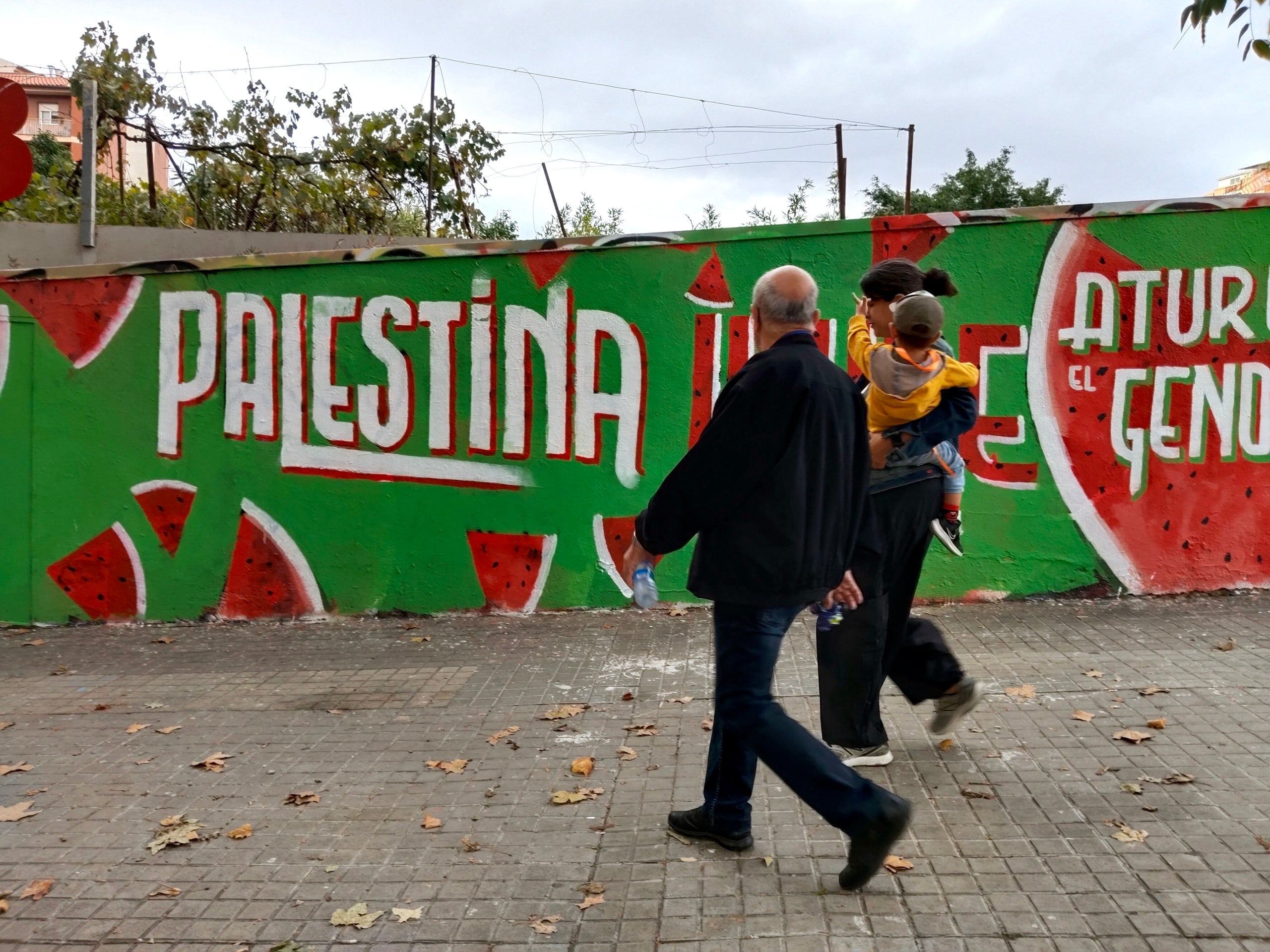 Una família passa per davant del mural de Roc Blackblock | Gabriel González