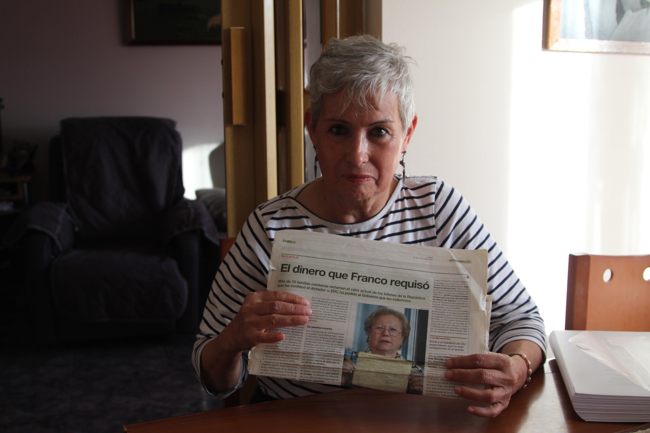 Lídia Jiménez sosté un article de premsa amb la fotografia de la seva mare Montserrat Capdevila, una de les afectades per les confiscacions franquisme | A.R.
