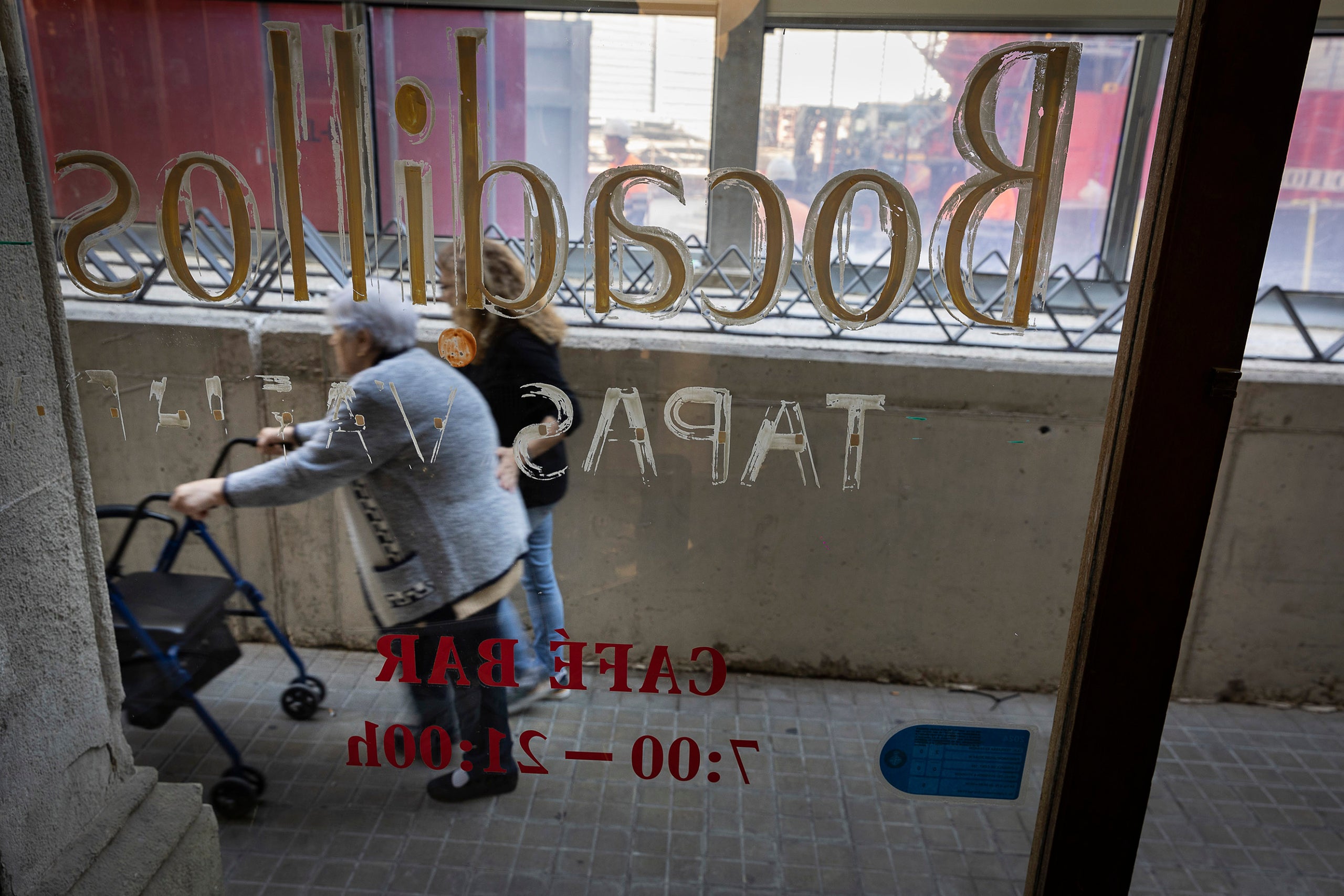 Dues dones passen per davant del Bar Urgell 1930, un dels comerços afectats per les obres del perllongament de l'L8 al carrer d'Urgell JORDI PLAY