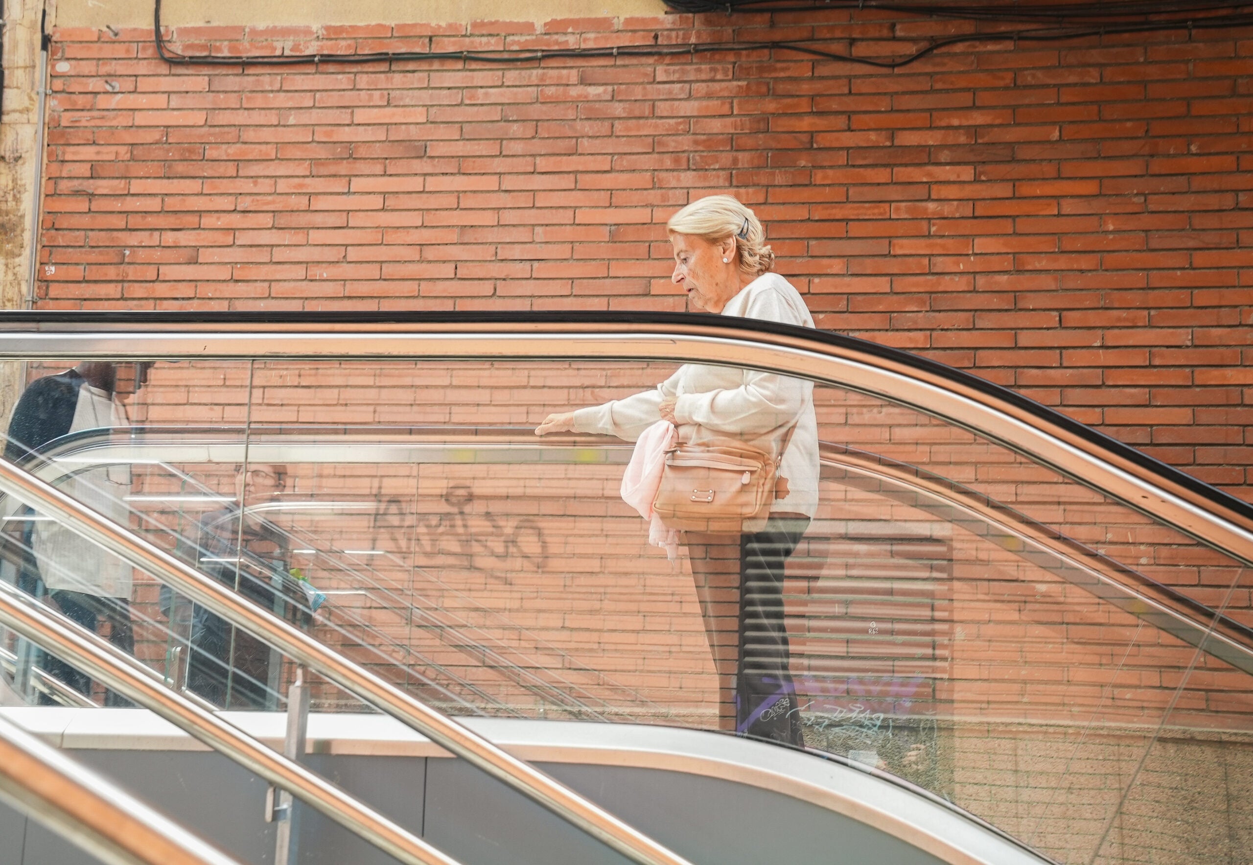 Una mujer utiliza las nuevas escaleras mecánicas de la Baixada de la Glòria / Ayuntamiento